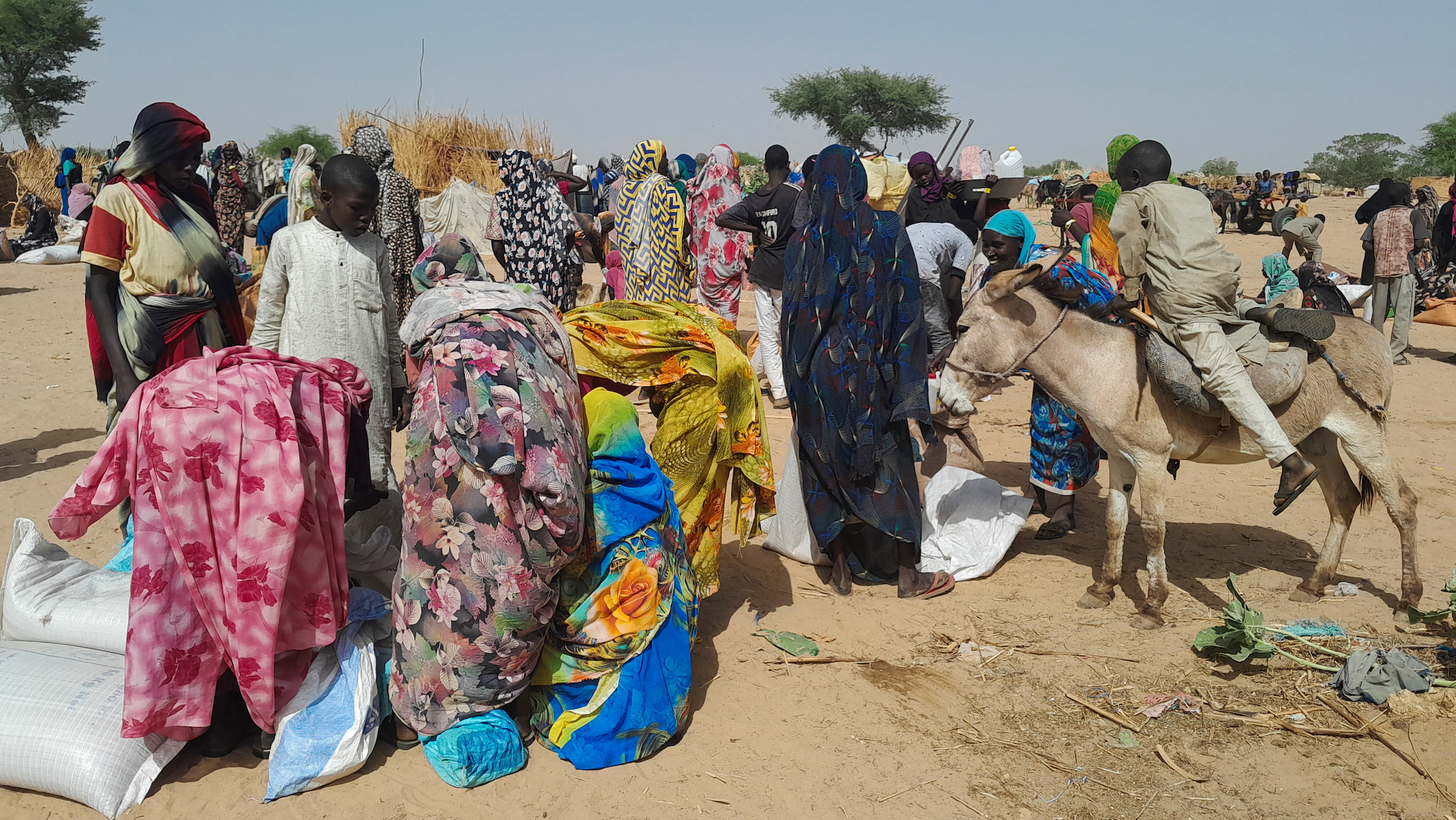 Sudanese refugees who fled the violence in their country, gather for food given by the World Food Programme (WFP) near the border between Sudan and Chad, in Koufroun, Chad.