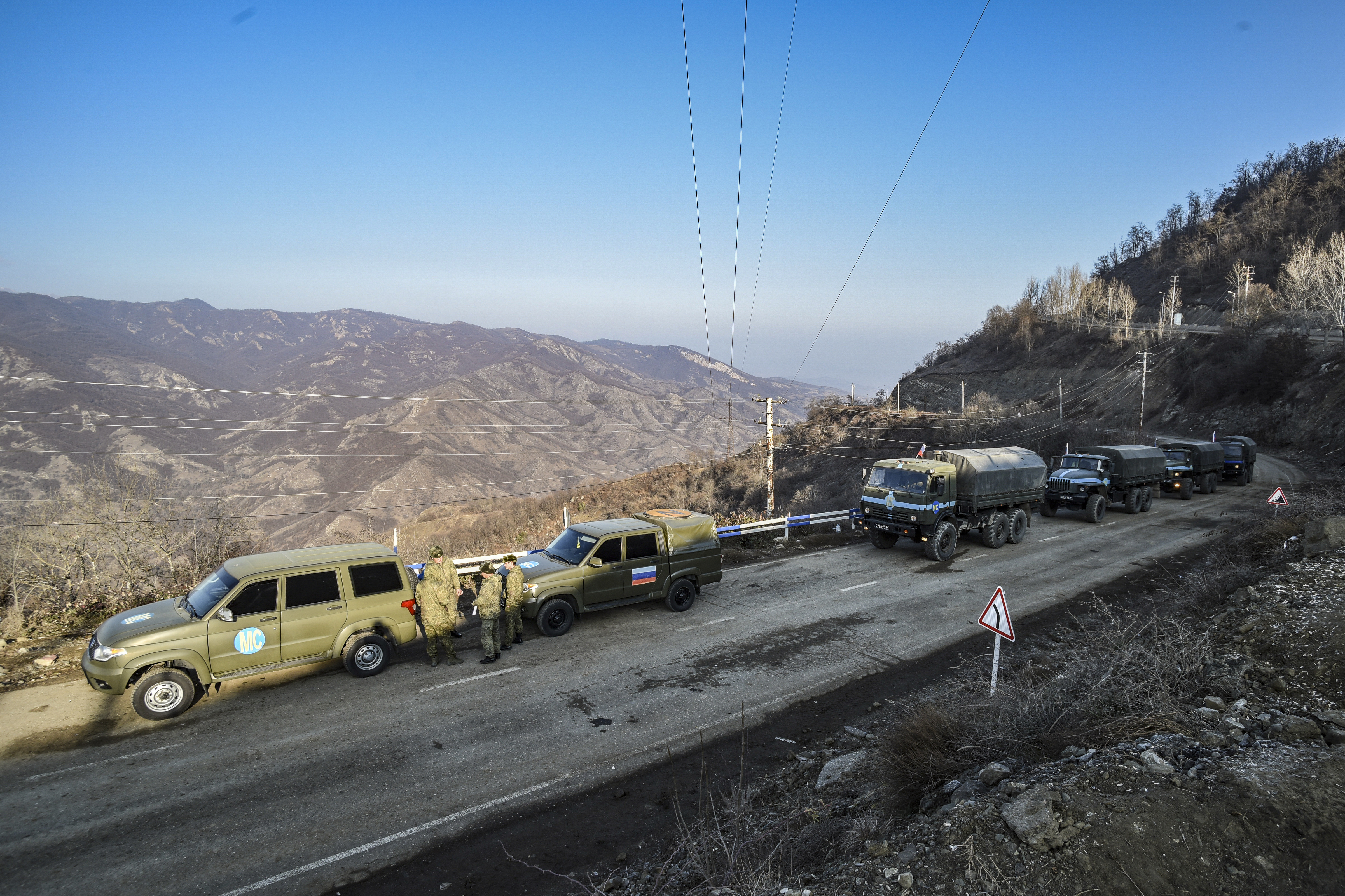 Russian peacekeepers are seen deployed at the Lachin corridor, the Armenian-populated breakaway Nagorno-Karabakh region's only land link with Armenia, as Azerbaijani environmental activists protest what they claim is illegal mining, on December 26, 2022. Azerbaijani activists who have blocked the sole road connecting Karabakh with Armenia rejected on December 26 Yerevan's accusations of provoking a humanitarian crisis in the enclave. But locals in Karabakh interviewed by AFP decried the dire consequences of the blockade, which they say is aimed at chasing ethnic Armenians from the region. (Photo by TOFIK BABAYEV / AFP)