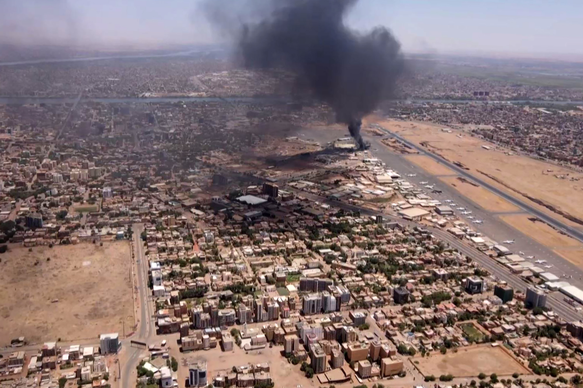 Black smoke rises into the air over a Khartoum neighbourhood.