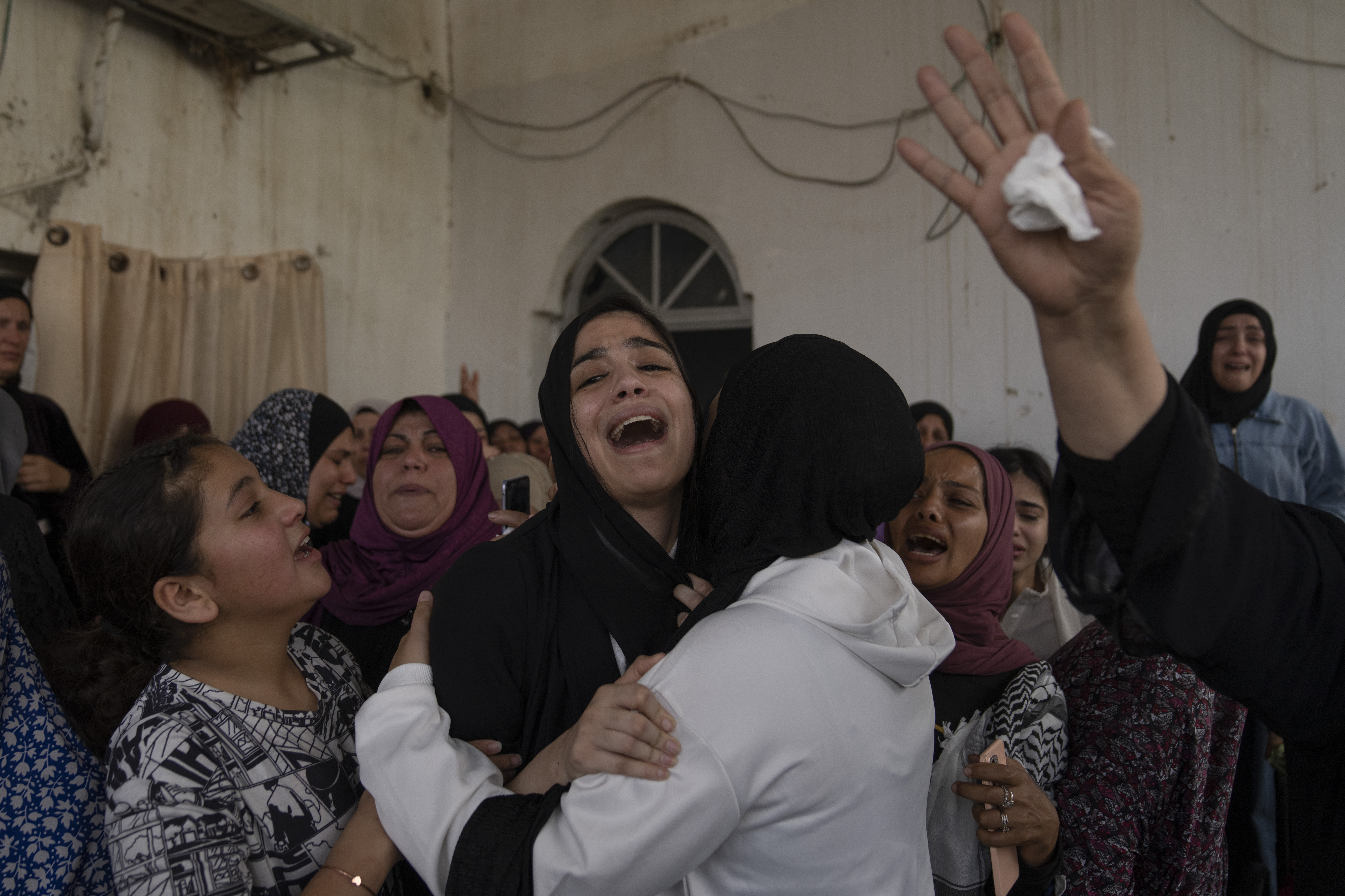 Palestinian mourners cry after taking the last look at the body of Mohammad Balhan