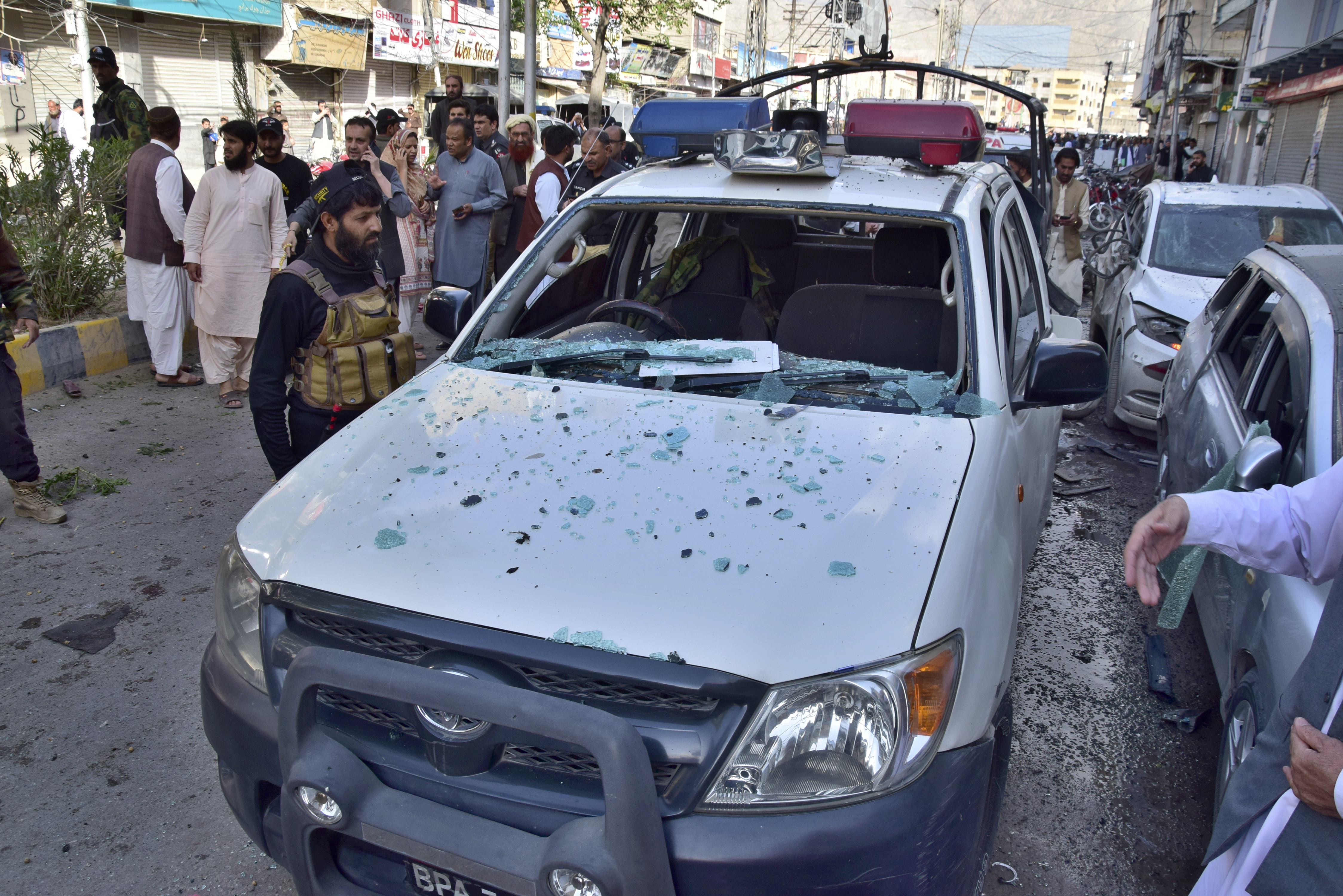 Police officers examine a damaged police vehicle at the site of bomb blast, in Quetta, Pakistan, Monday, April 10, 2023. A roadside bomb targeting a police vehicle in volatile southwestern Pakistan on Monday killed few people and wounded more than dozen others, mostly civilian pedestrians, a government spokesperson said. (AP Photo/Arshad Butt)