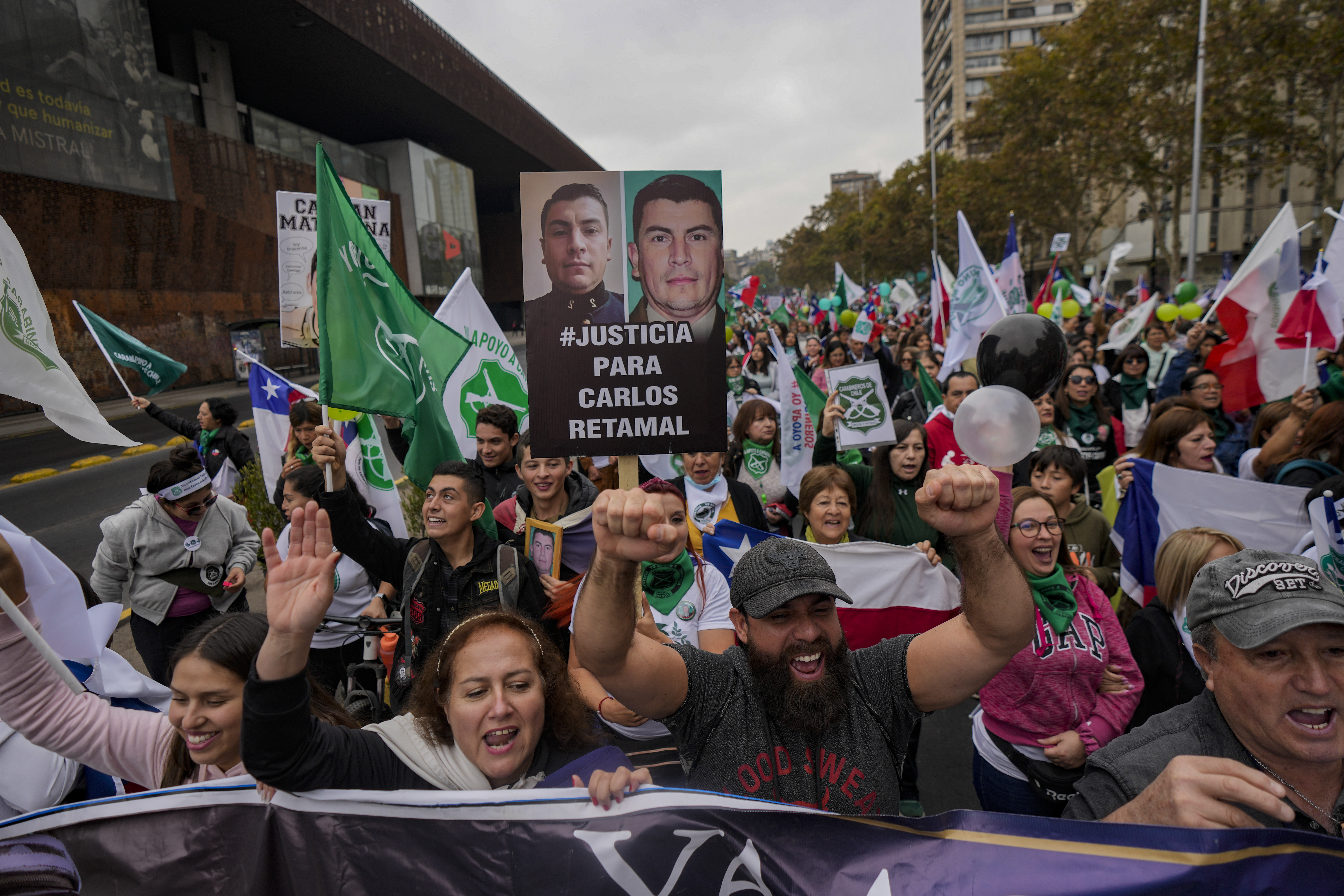 Protesters and relatives of police officers who were killed in the line of duty take part in a march called by their relatives amid an increase in violent crime, in front of the La Moneda presidential palace.