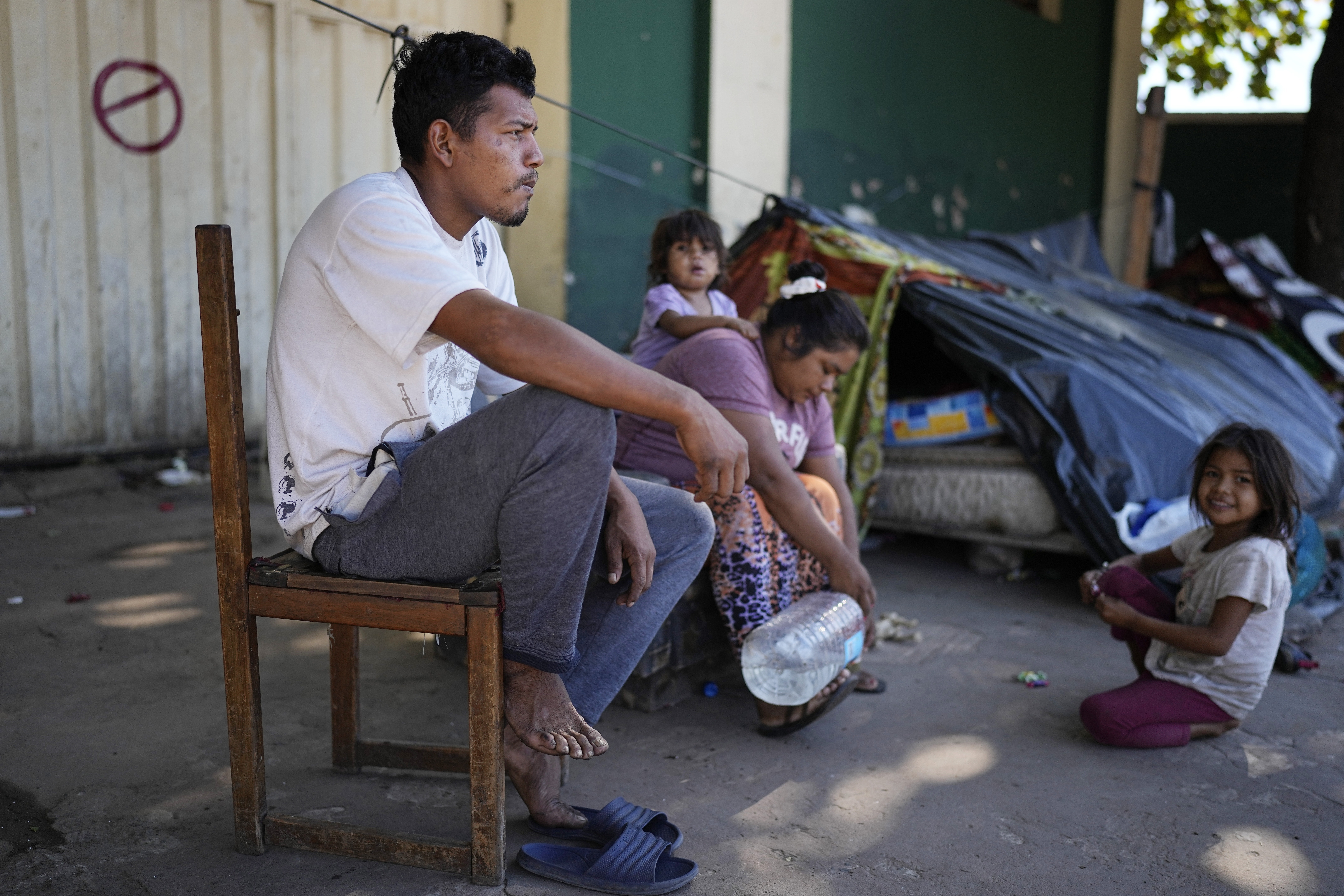 Ava Guarani Indigenous husband and wife, Juan Domingo and Vilma, from Canindeyu, camp out with their daughters near the National Indigenous Office (INDI) to demand food aid in Asuncion, Paraguay, Friday, April 28, 2023. Paraguay's general elections are set for April 30. (AP Photo/Jorge Saenz)