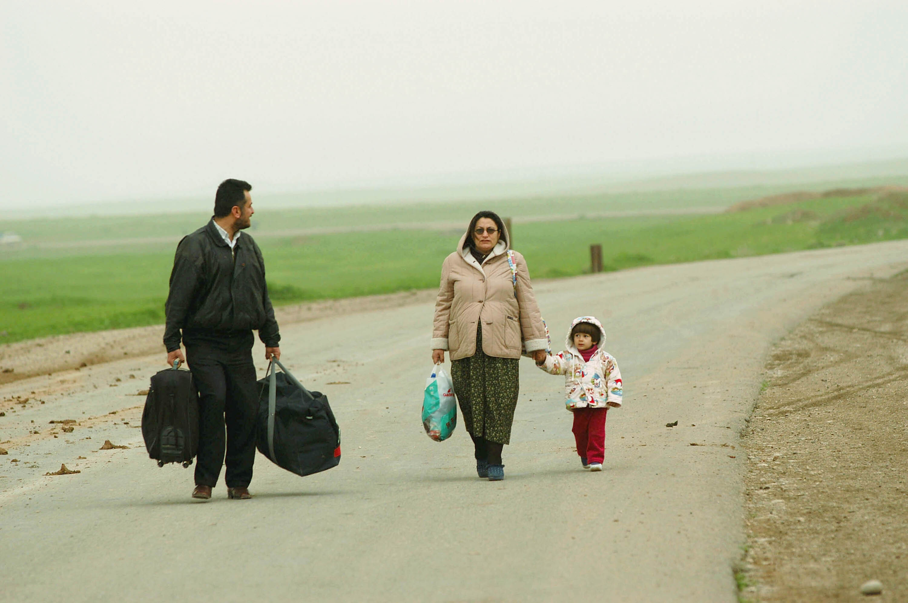 ERBIL, NORTHERN IRAQ - MARCH 19: A father from Baghdad is fleeing Iraq at the Qoshtapa checkpoint near Erbil with his preganant wife and daughter. Imminent war has created a constant stream of refugees into Northern Iraq in the face of an attack by Iraq. (Photo Patrick Barth/Getty Images)