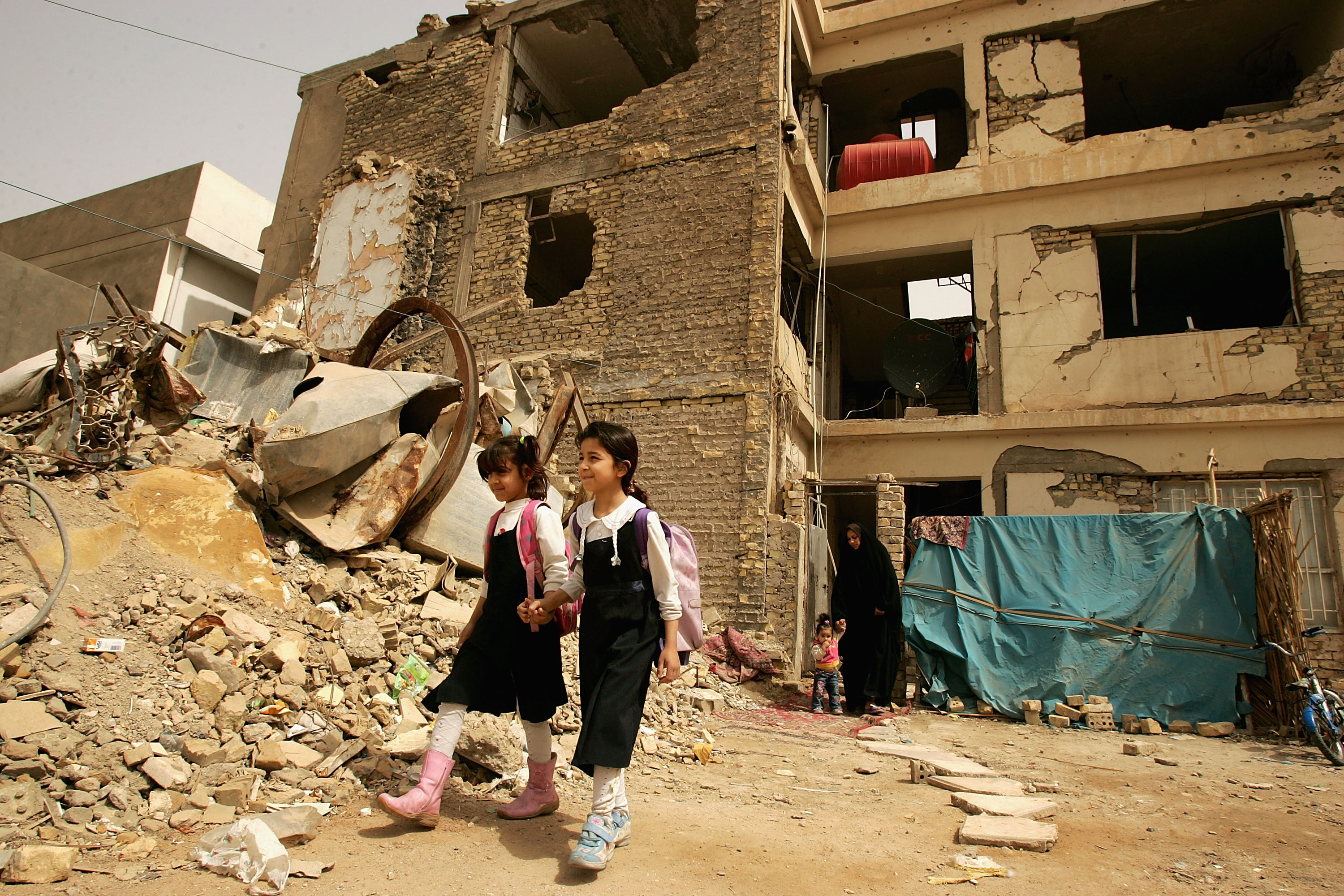 BAGHDAD, IRAQ - MARCH 19: Internally displaced girls go to school on March 19, 2008 as they live in a bombed building in Baghdad, Iraq. An internally displaced Iraqi family has taken a bombed building as its home in Baghdad, Iraq. According to a global relief agency, about one in five of Iraq?s population, five years ago, is refugees or living as internally displaced people. (Photo by Wathiq Khuzaie /Getty Images)