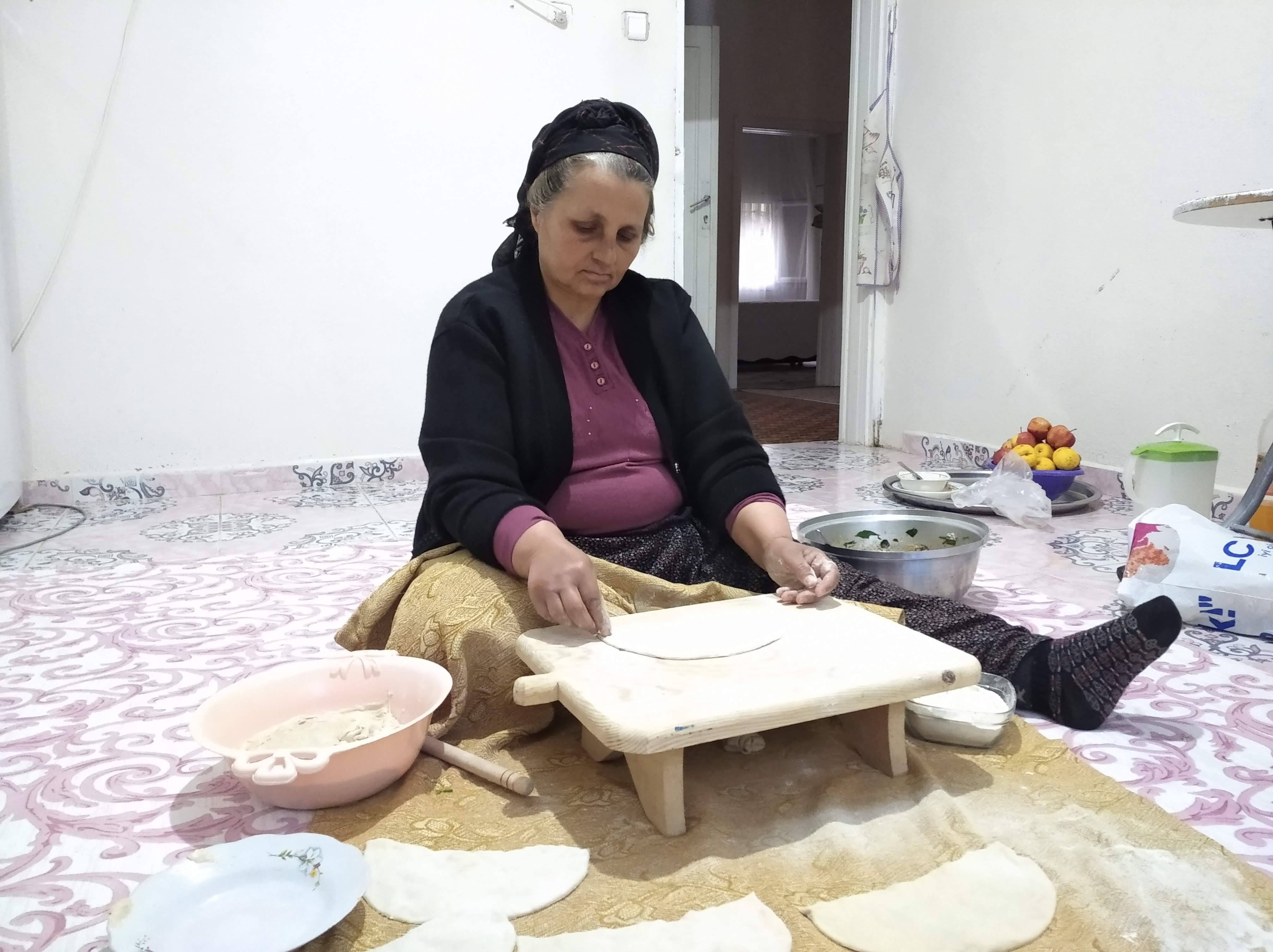 Sevim Artar, 54, sits on the kitchen floor preparing food for her and her son Yusuf for iftar.