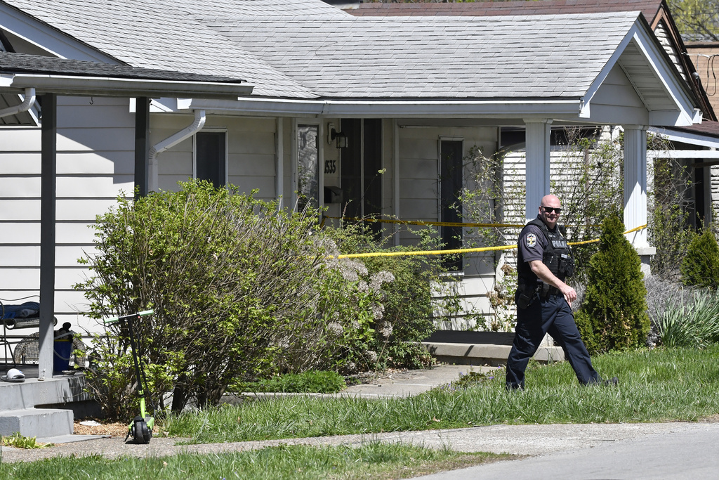 A police officer walks outside of the home of the man who carried out the attack on Monday