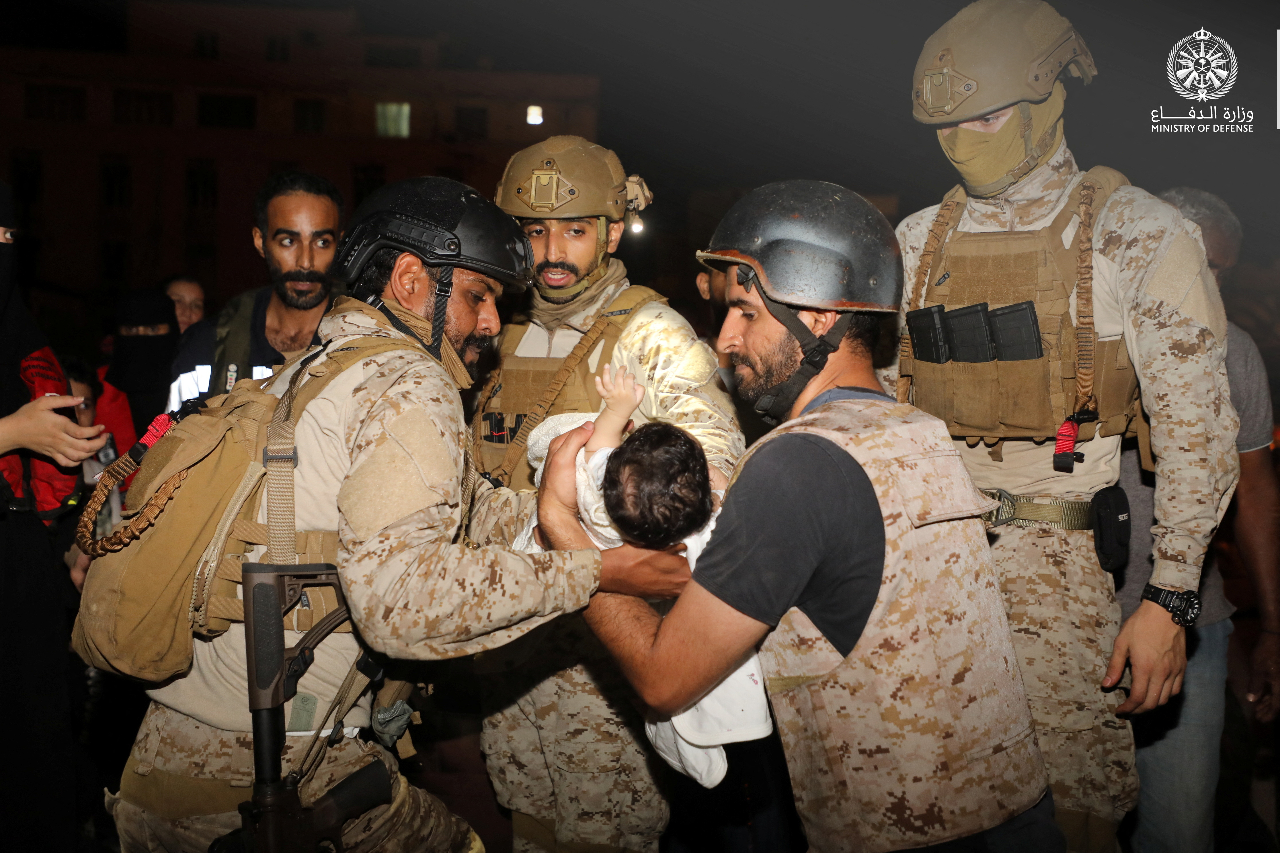 Saudi Royal Navy officers assist a child aboard their navy ship as they evacuate Saudis and other nationals from Sudan to escape the conflict.