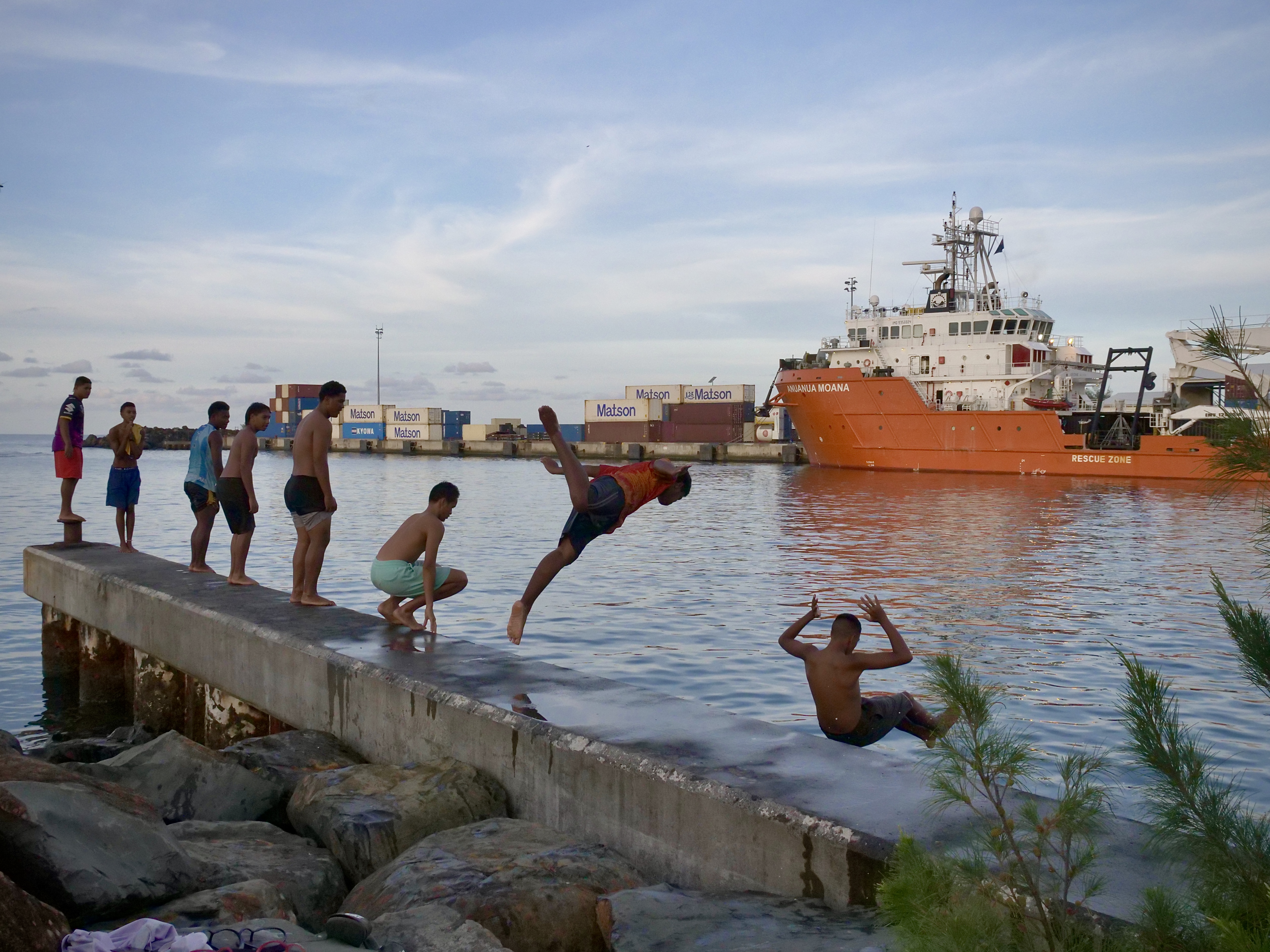 Teenagers jump off a pier