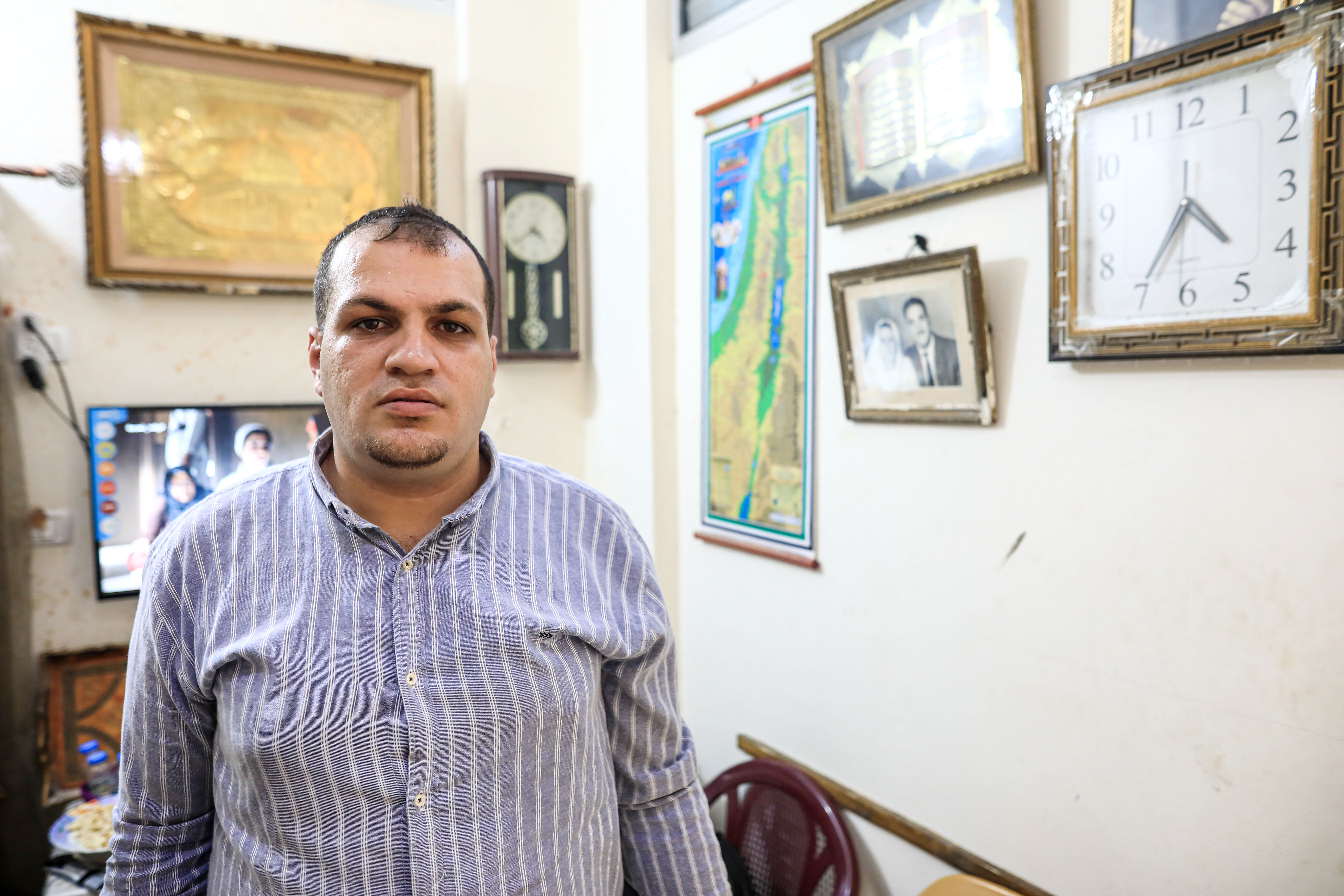A young man stands in next to a wall 