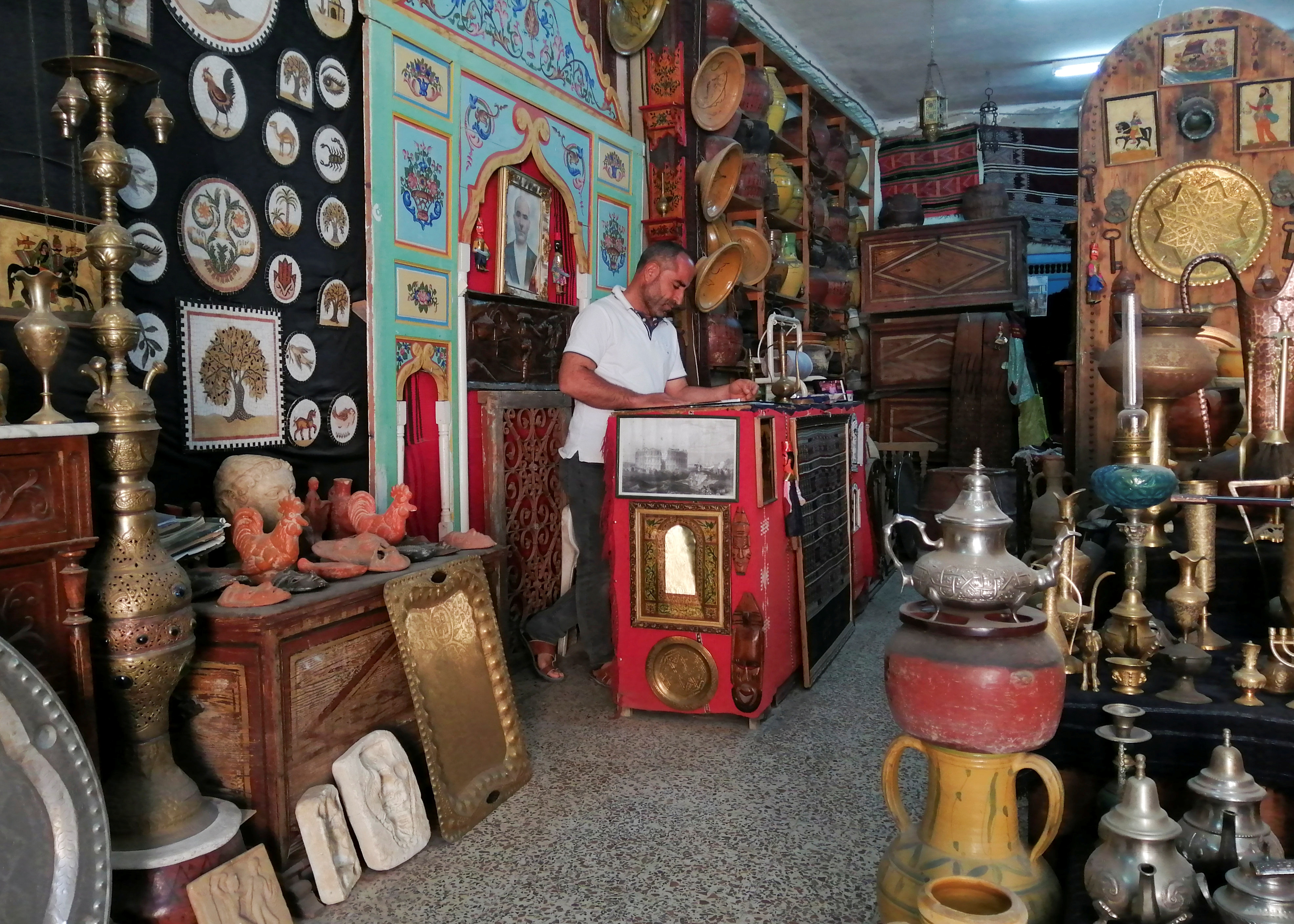 Aroussi Obay, 42, stands inside his souvenir shop in El Jem