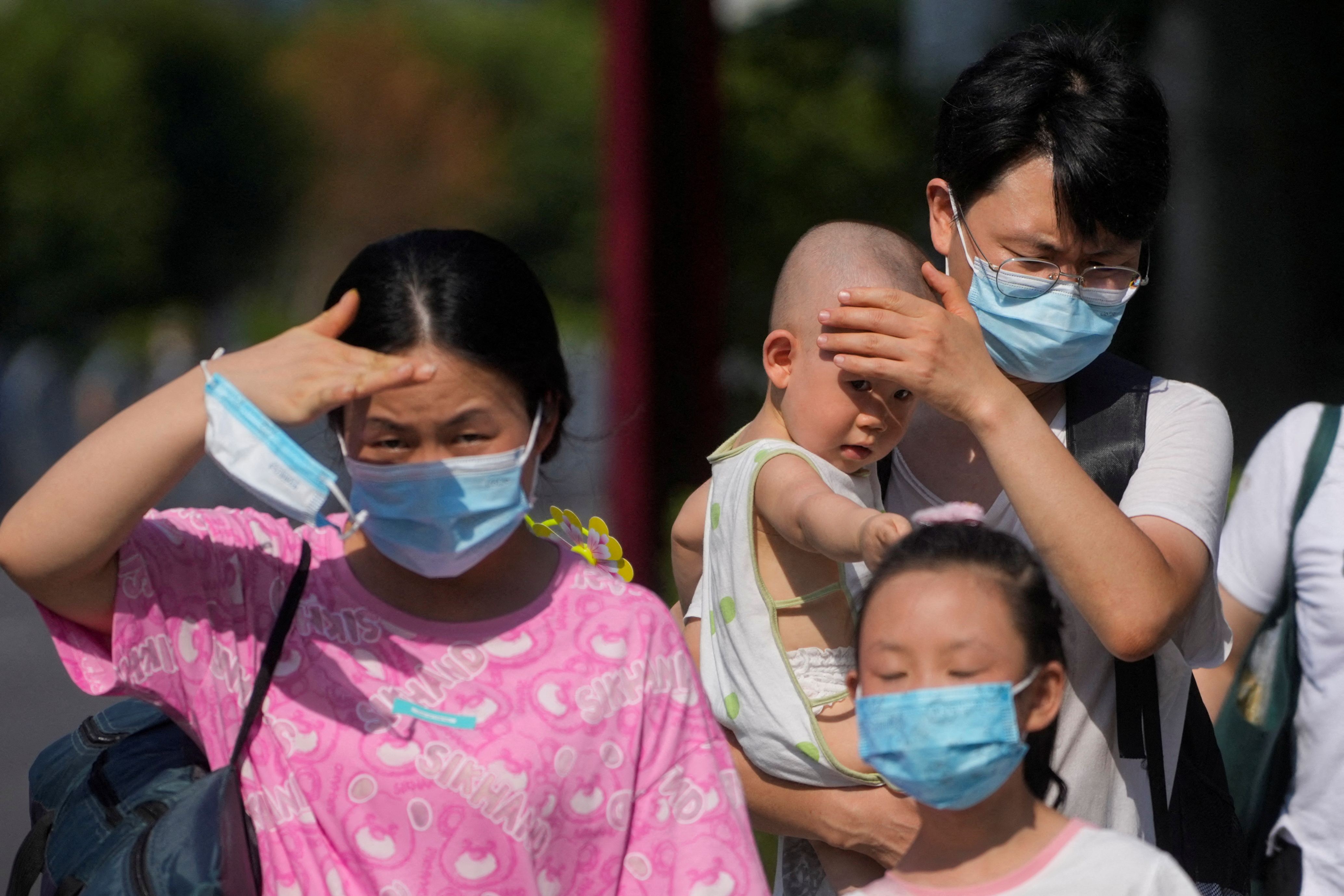 People block the sunlight with their hands on a street amid a heatwave warning in Shanghai, China July 23, 2022. [File: REUTERS/Aly Song]