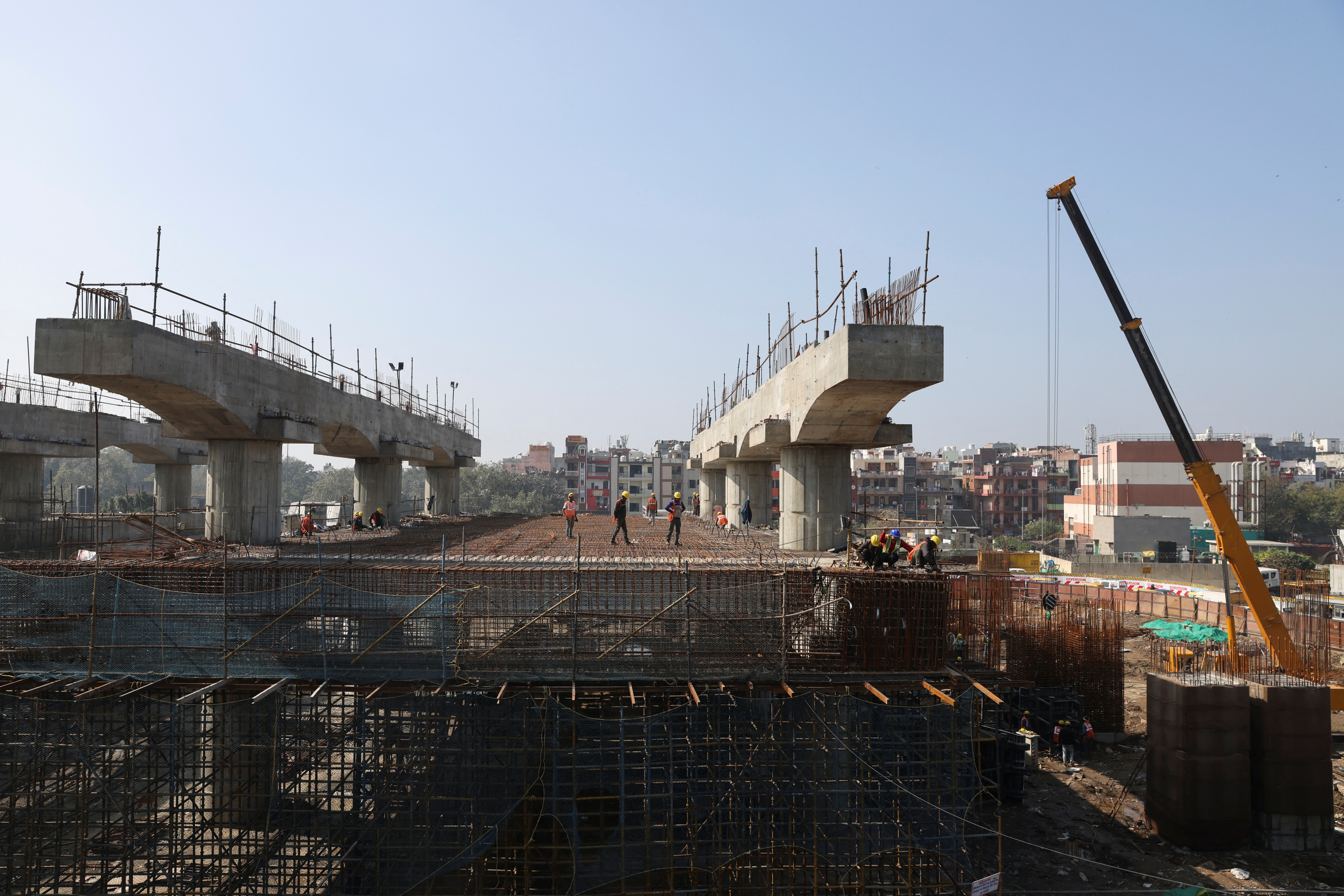 Labourers work at a construction site of a metro rail project, in New Delhi, India, February 1, 2023. REUTERS/Anushree Fadnavis