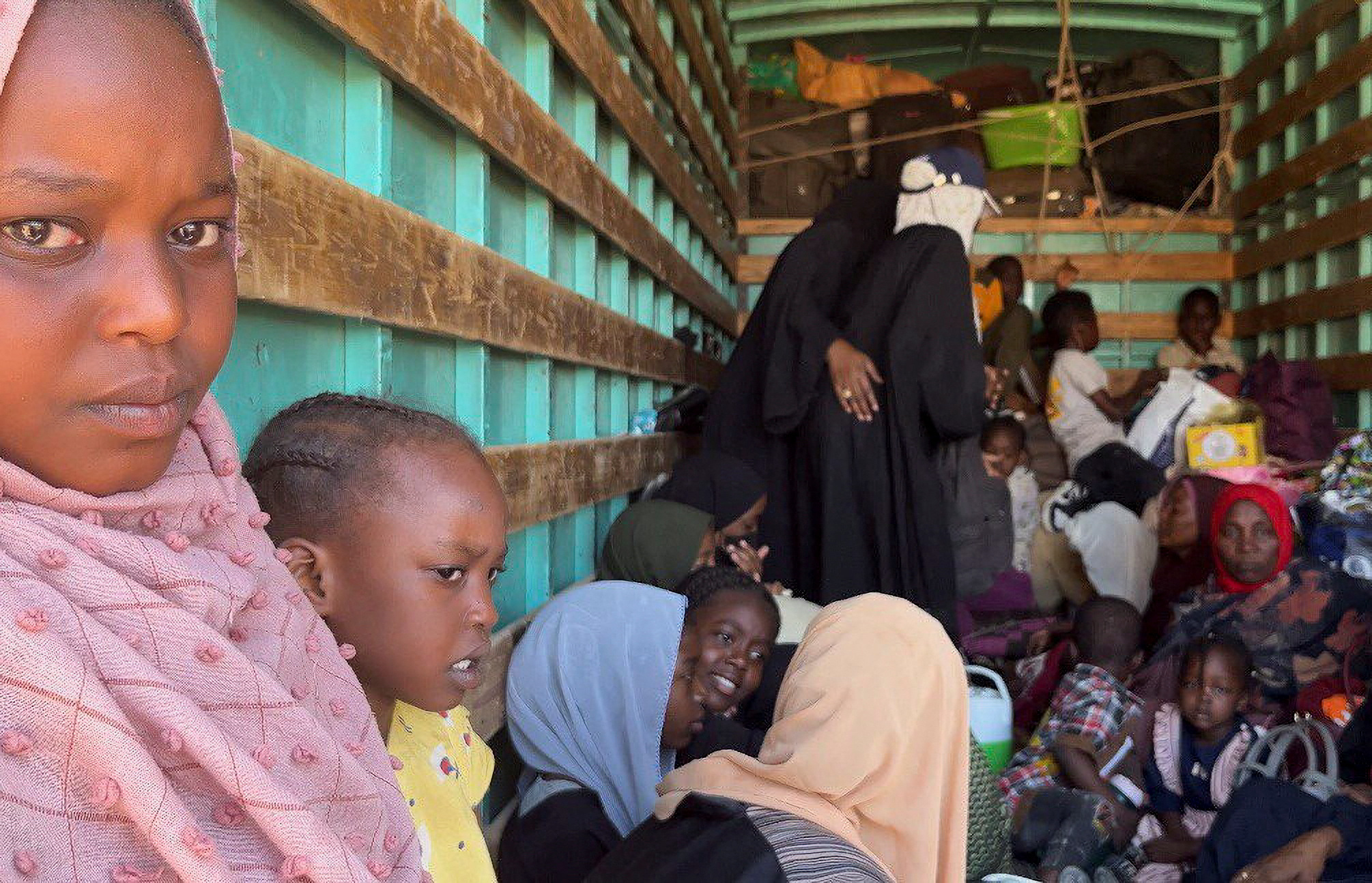 Sudanese families are seen inside a truck after the crisis in Sudan's capital Khartoum on their way to Egypt through the Qustul border in the Sudanese city of Wadi Halfa, Sudan