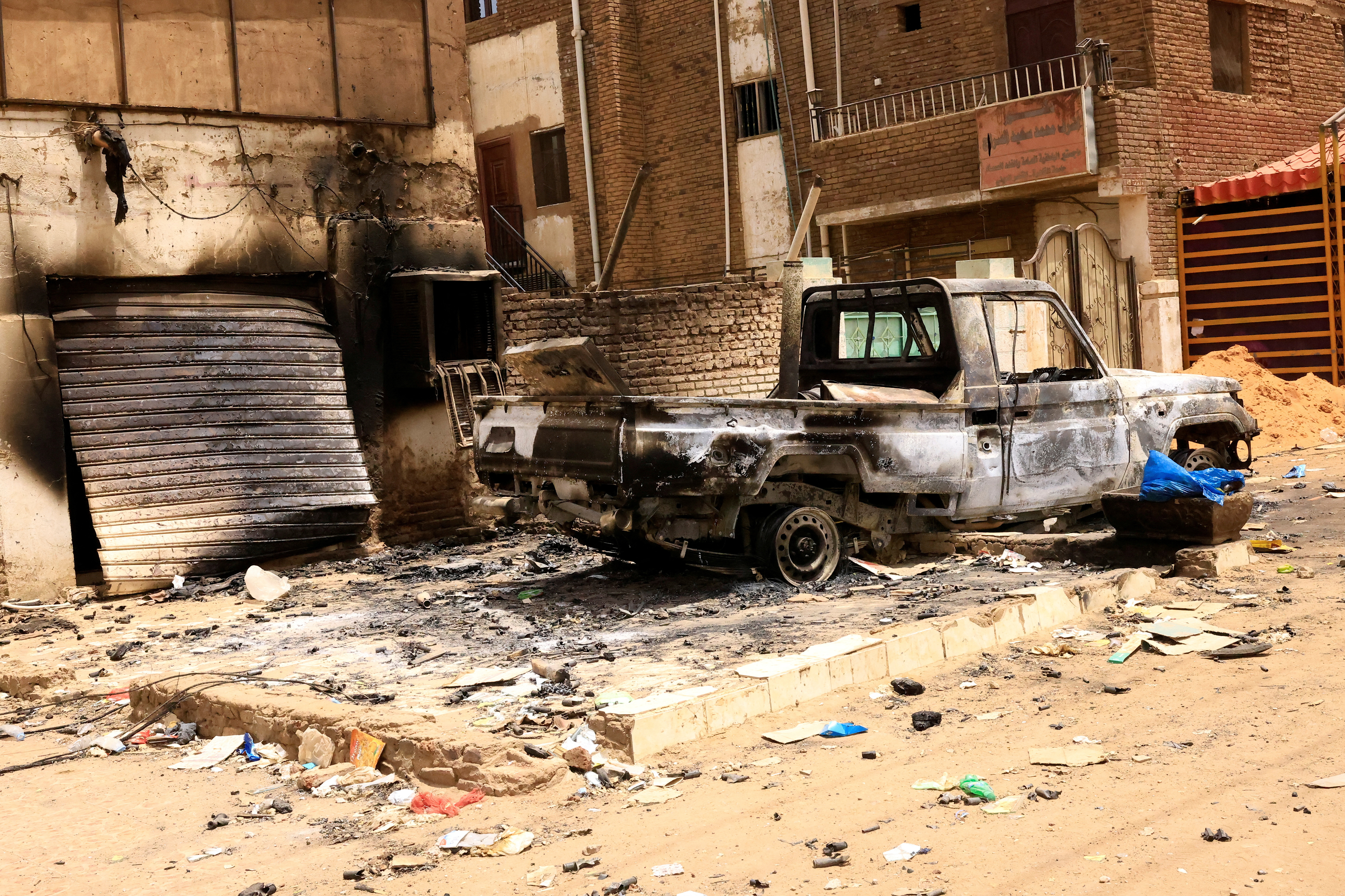 Damaged buildings and burned-out pickup truck are seen at the central market during clashes between the paramilitary Rapid Support Forces and the army in Khartoum North, Sudan.