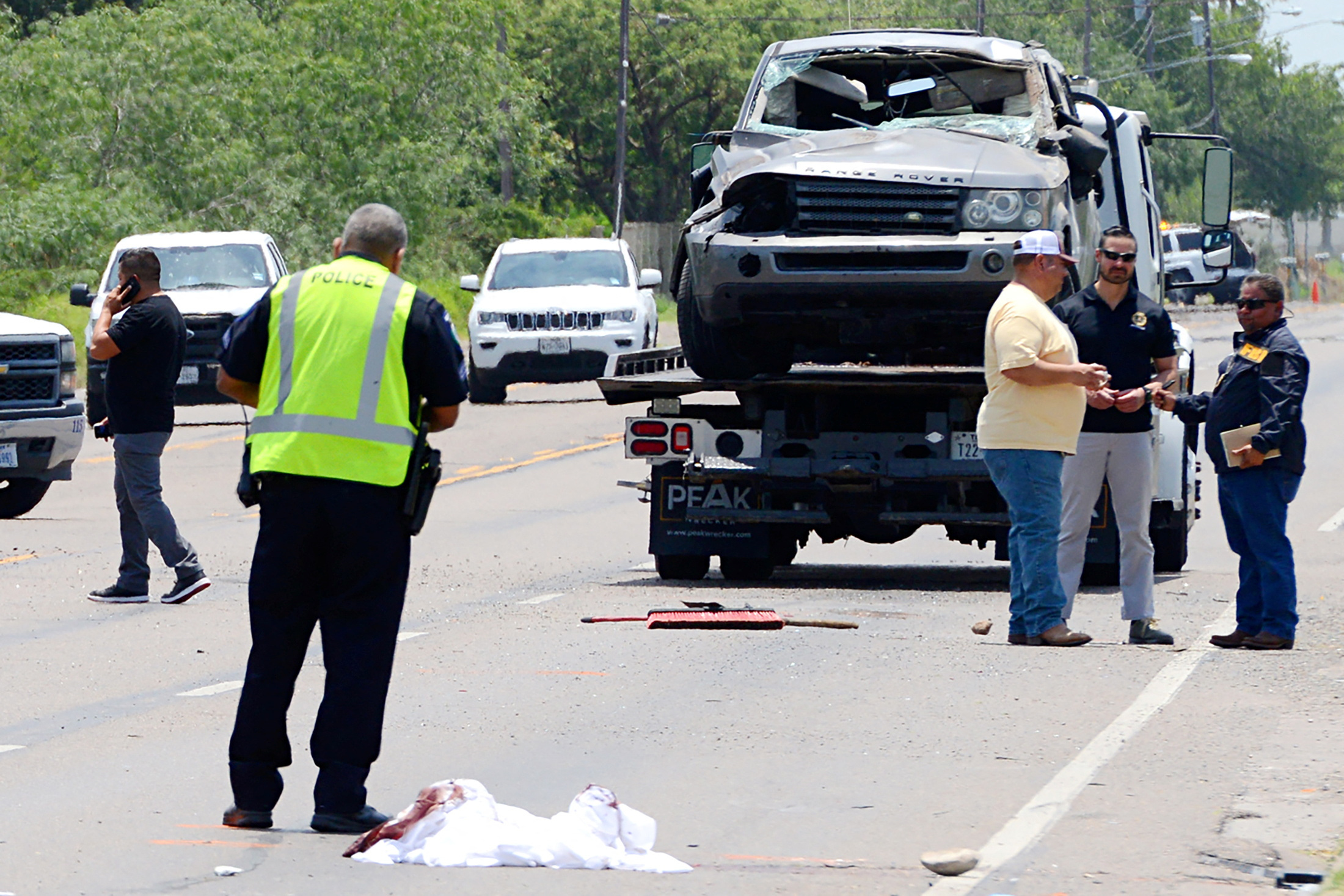 An SUV is removed from a street after it rammed into people outside a migrant centre in Brownsville, Texas