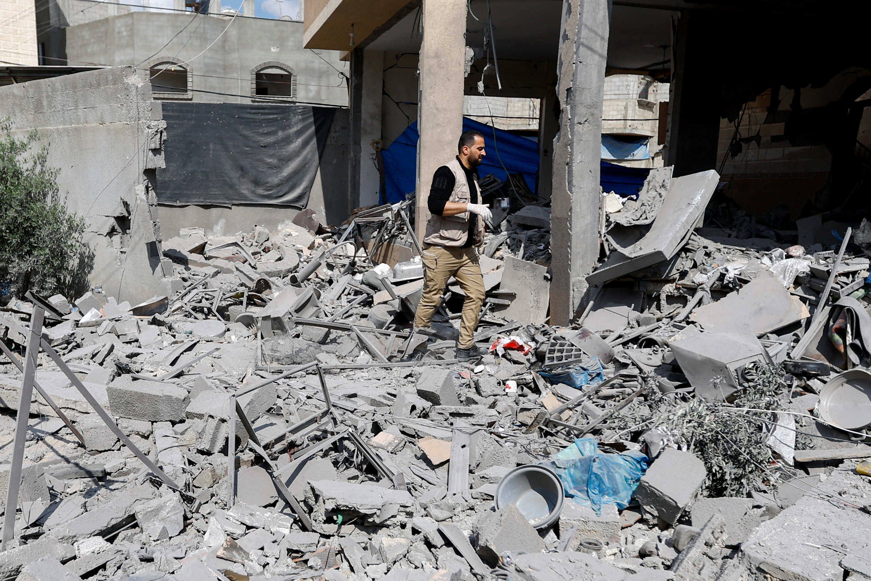A man inspects the damage at a house where senior Palestinian Islamic Jihad commander Jihad Ghannam and his wife Wafa were killed in an Israeli strike