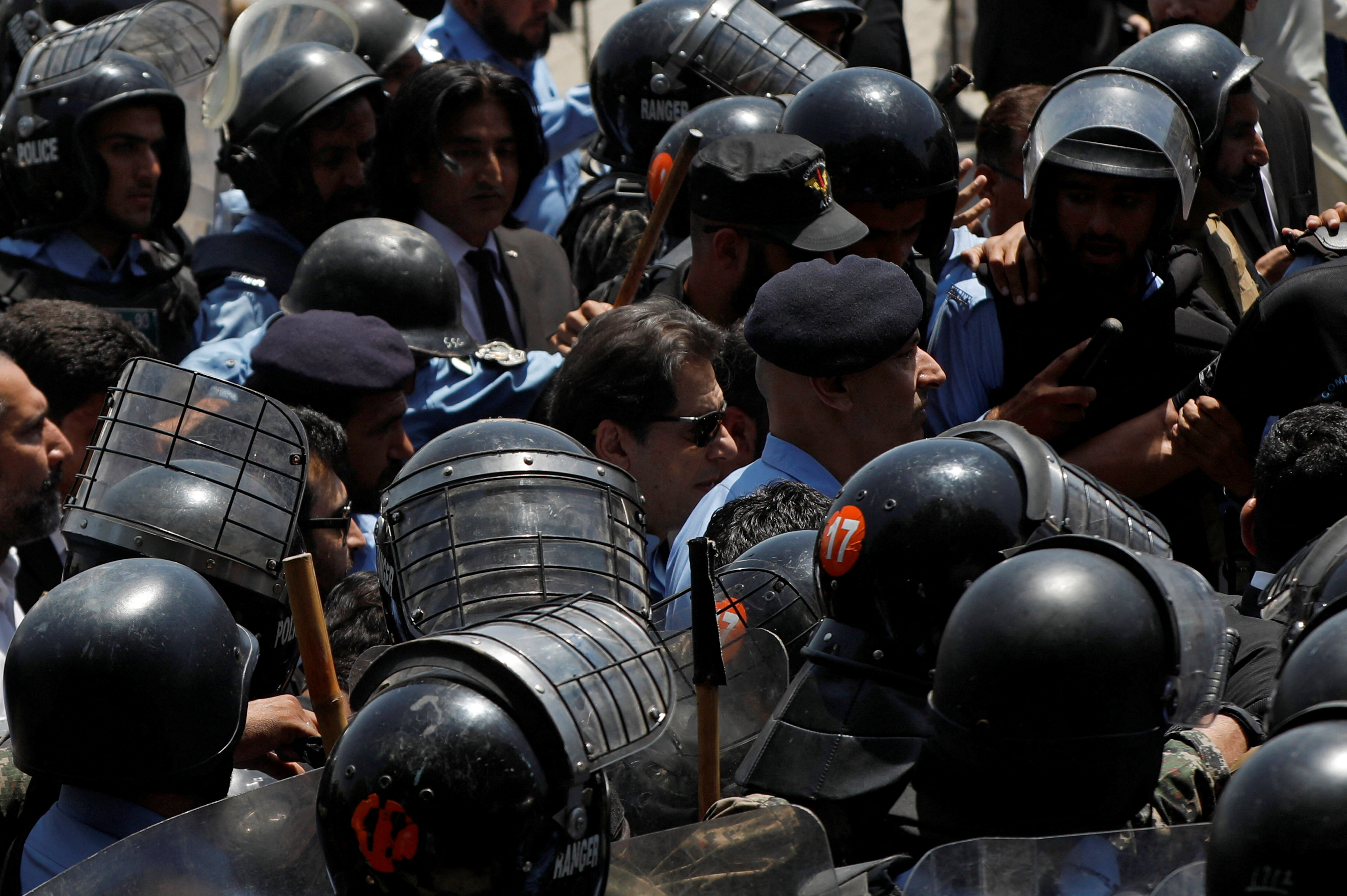 Security officers escort Pakistan's former Prime Minister Imran Khan as he arrives to appear before the high court in Islamabad, Pakistan May 12, 2023.