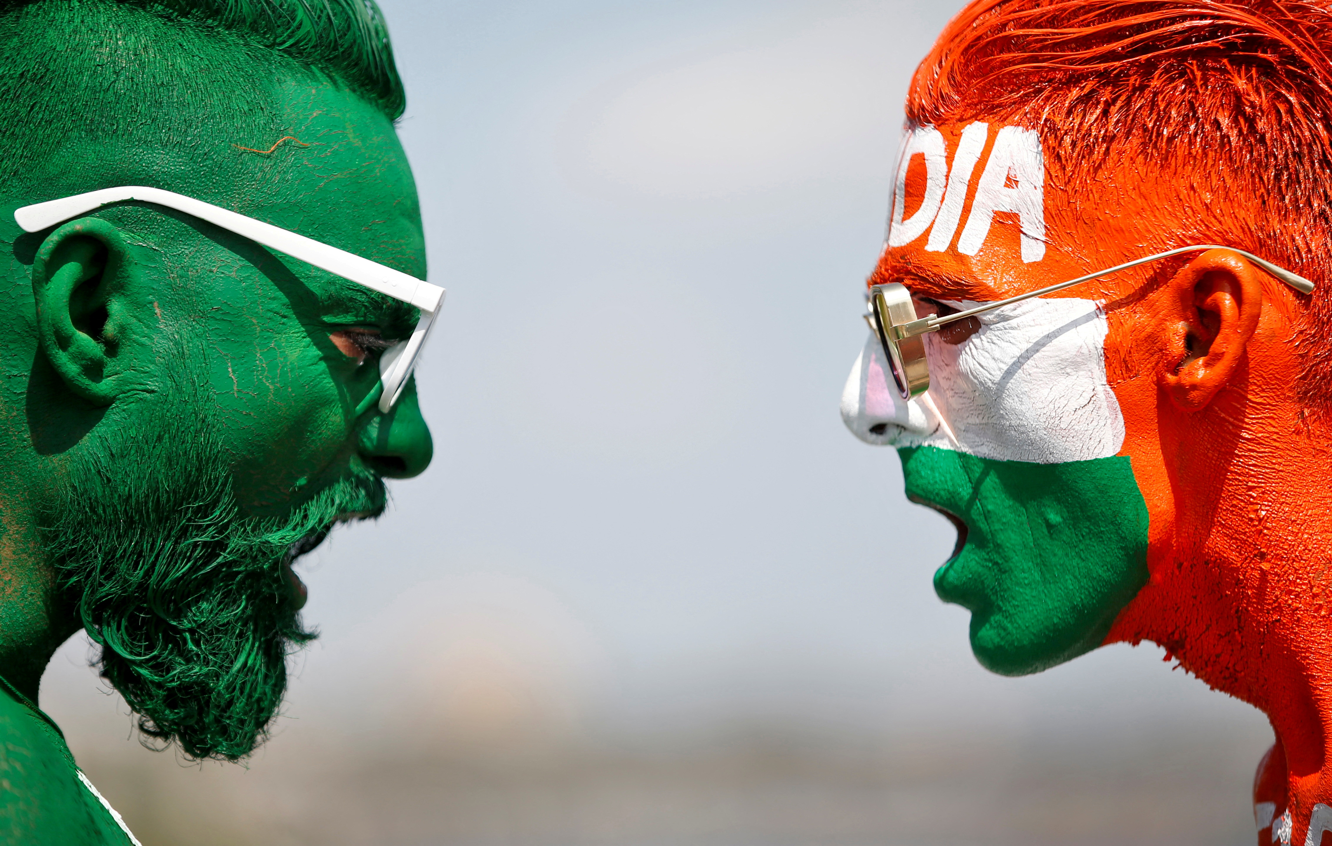 Cricket fans with their faces painted in the Indian and Pakistani national flag colours