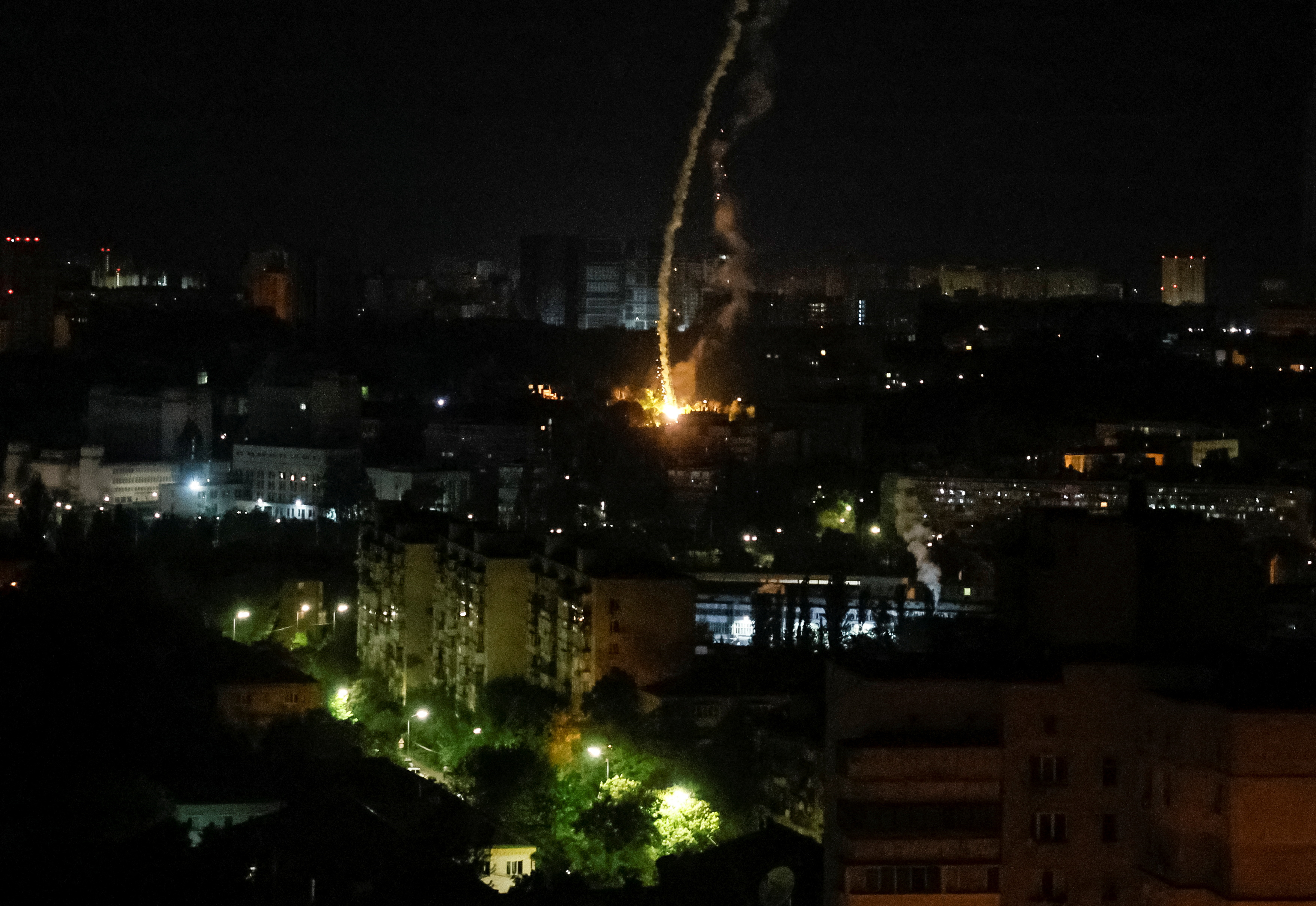 An explosion of a missile is seen in the city during a Russian missile strike