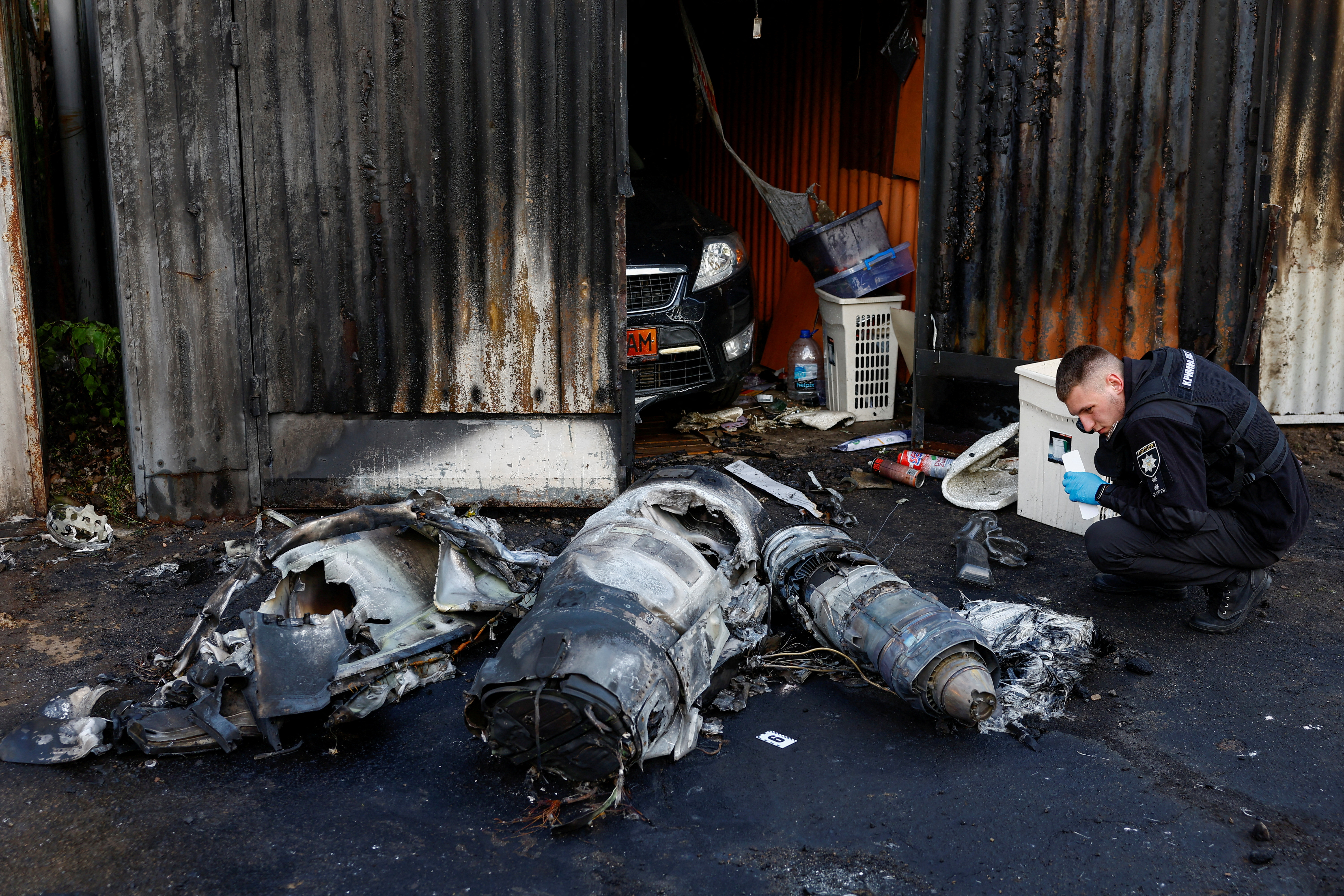 Police officer inspects remains of a Russian cruise missile shot down by Air Defence Forces, amid Russia's attack on Ukraine, in Kyiv, Ukraine May 18, 2023. REUTERS/Valentyn Ogirenko TPX IMAGES OF THE DAY