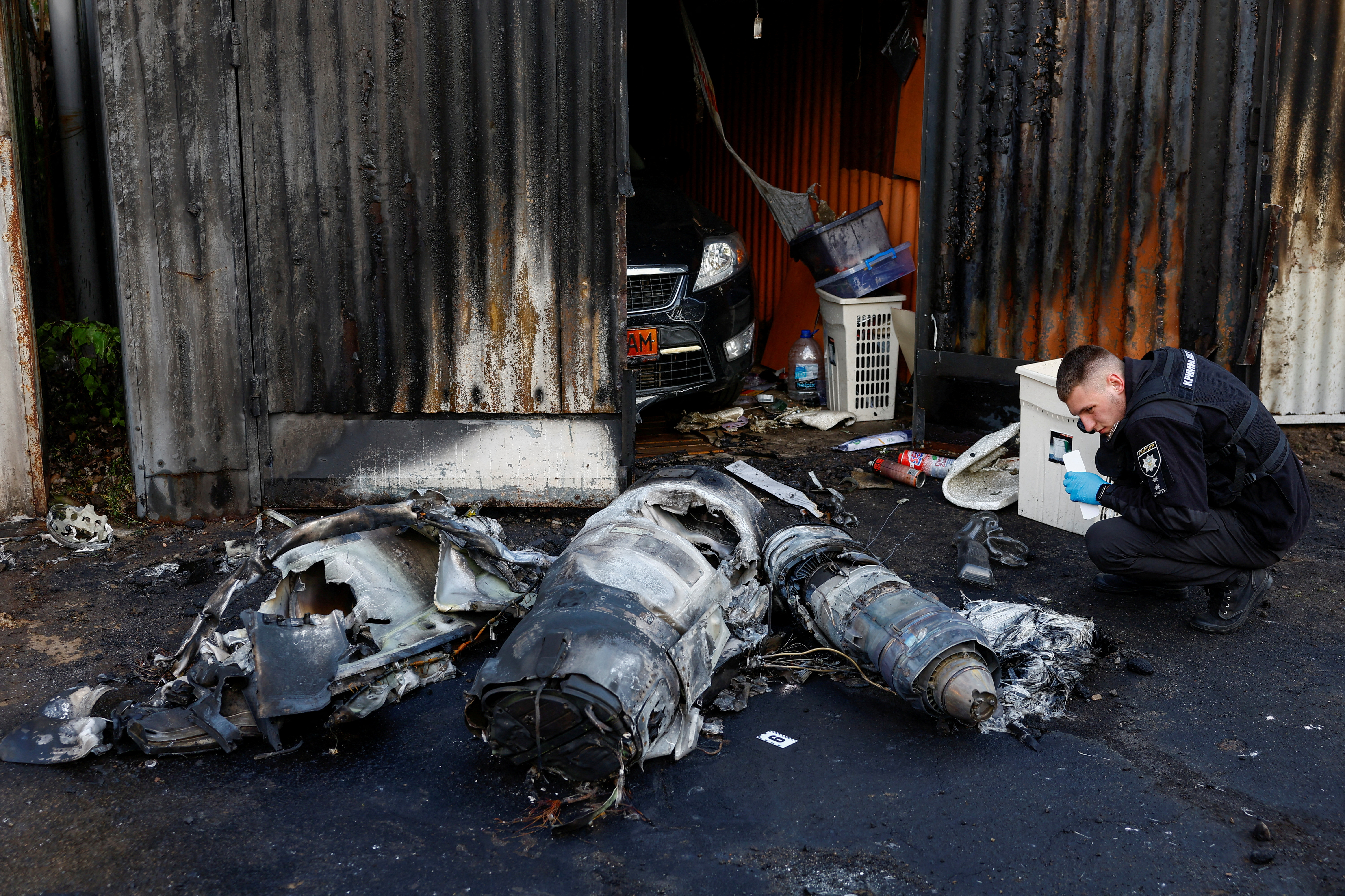 Police officer inspects remains of a Russian cruise missile shot down by Air Defence Forces, amid Russia's attack on Ukraine, in Kyiv, Ukraine May 18, 2023. REUTERS/Valentyn Ogirenko TPX IMAGES OF THE DAY