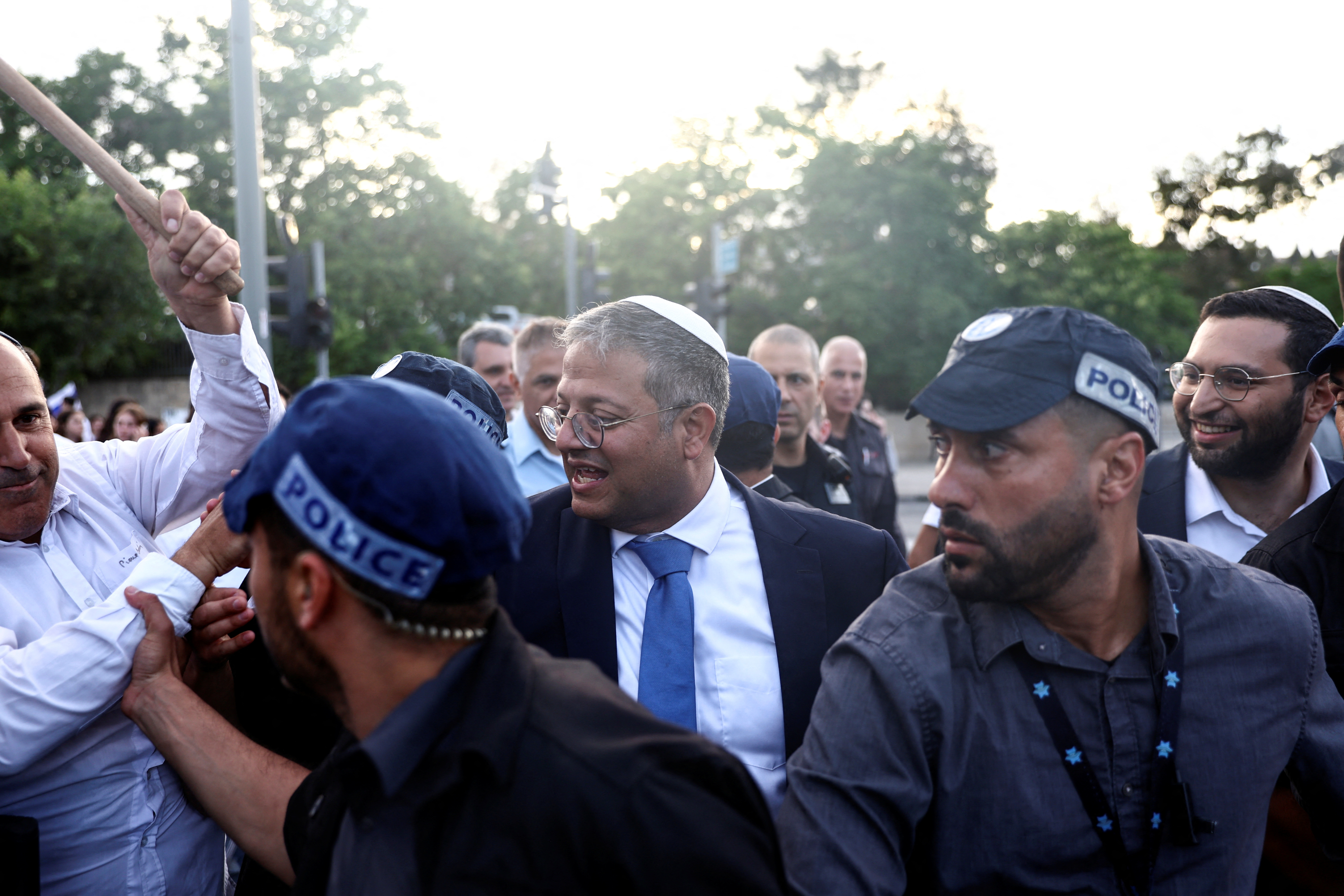 A security personnel pushes away an Israeli man as Israel's National Security Minister Itamar Ben-Gvir passes by Damascus gate to Jerusalem's Old city marking Jerusalem Day in Jerusalem May 18, 2023.