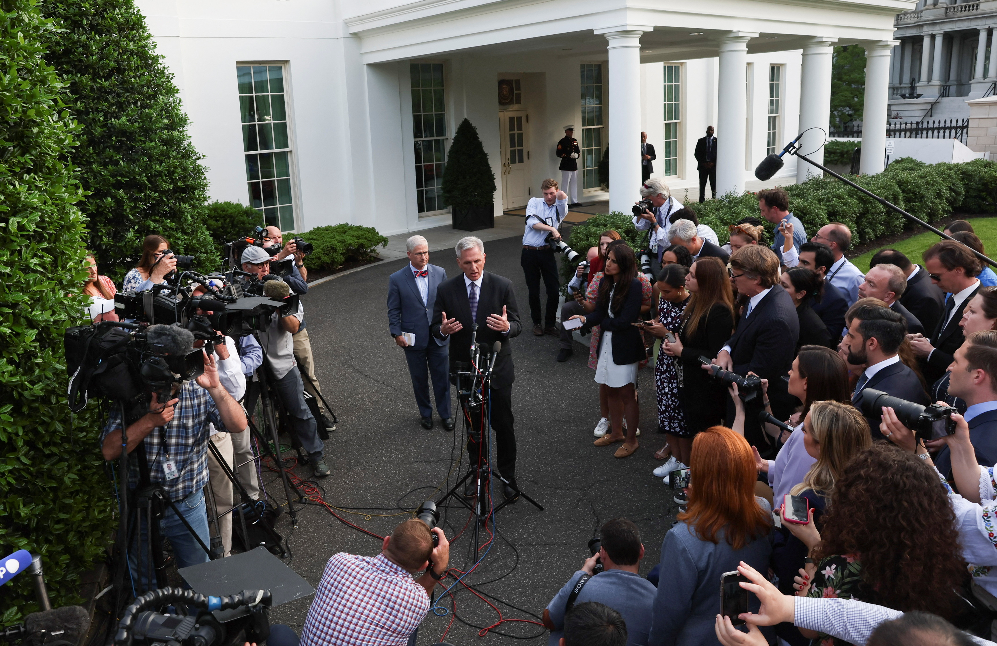 US House Speaker Kevin McCarthy speaks to reporters outside the West Wing of the White House with Representative Patrick McHenry behind him.