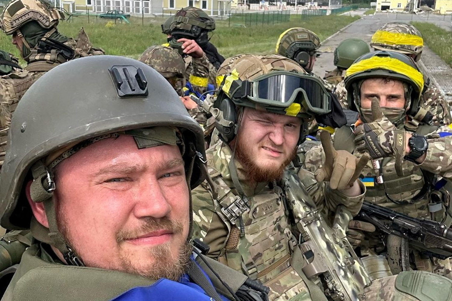 Members of Russian Volunteer Corps pose for a picture atop an armoured vehicle at Graivoron border crossing in Kozinka, Belgorod region, Russia,