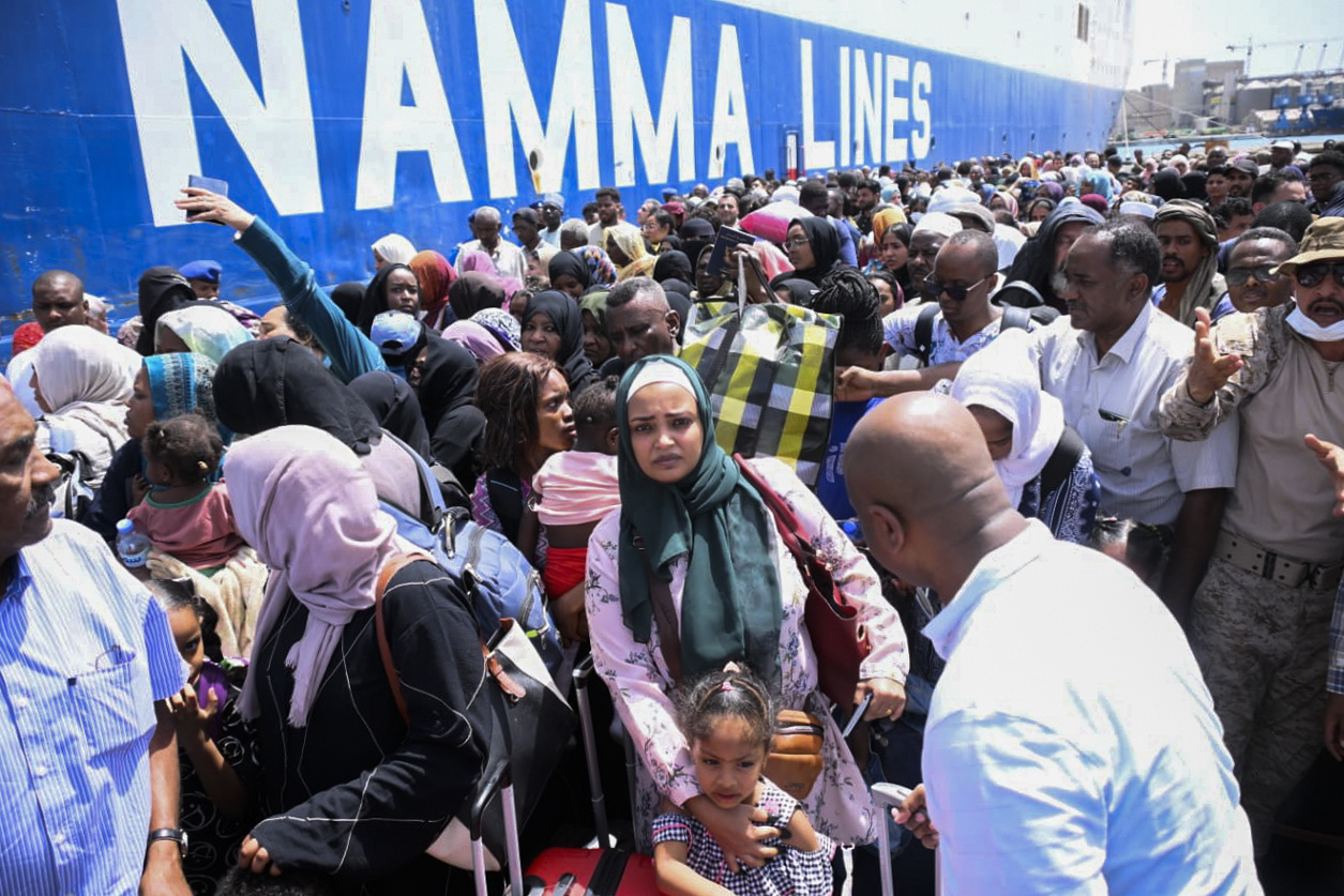 People fleeing war-torn Sudan queue to board a boat from Port Sudan