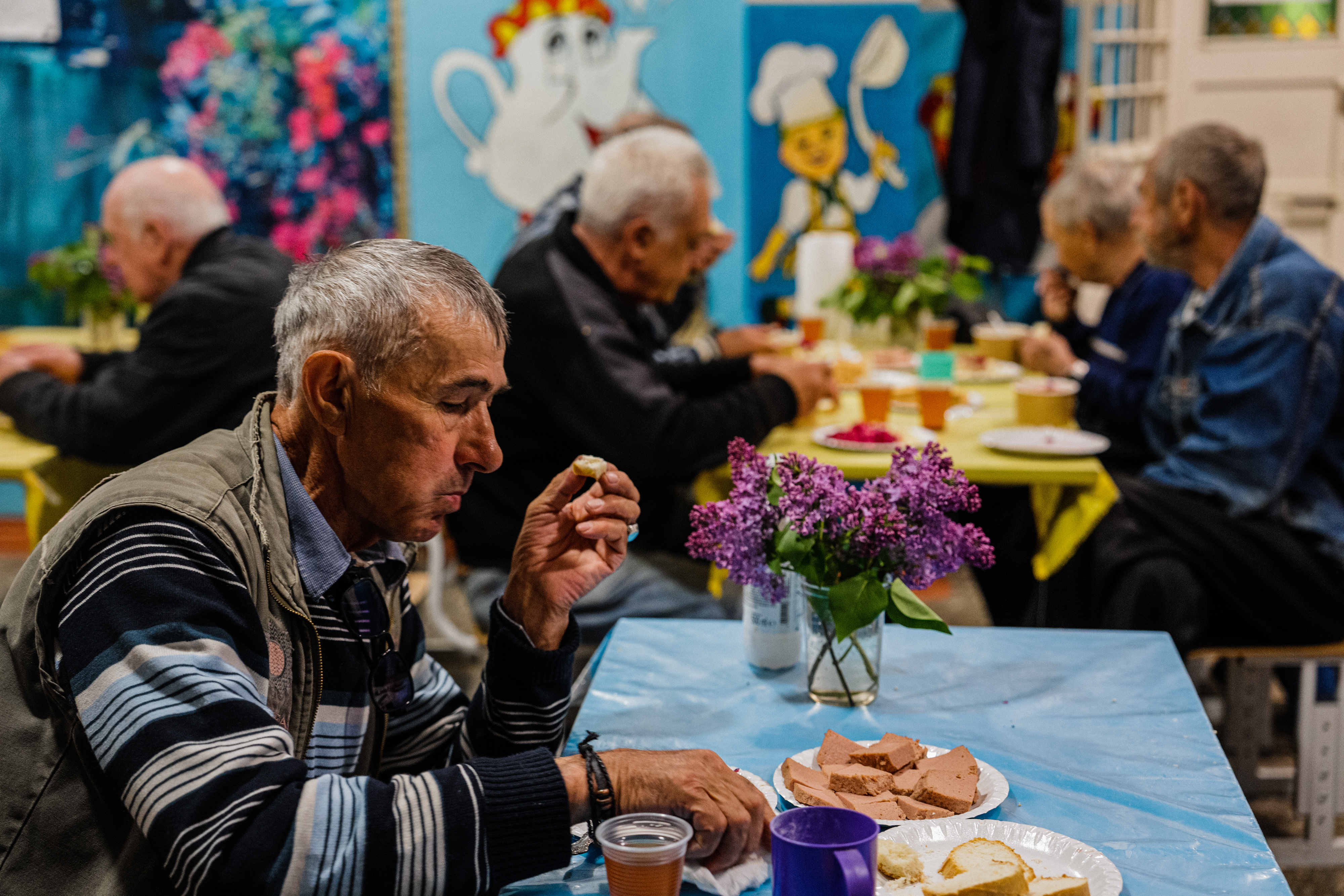 Local residents sit in a volunteer run shelter, providing access to laundry and bathroom facilities where they can warm up, charge their phones, drink hot tea and receive humanitarian aid in the town of Orikhiv, in the Zaporizhzhia region