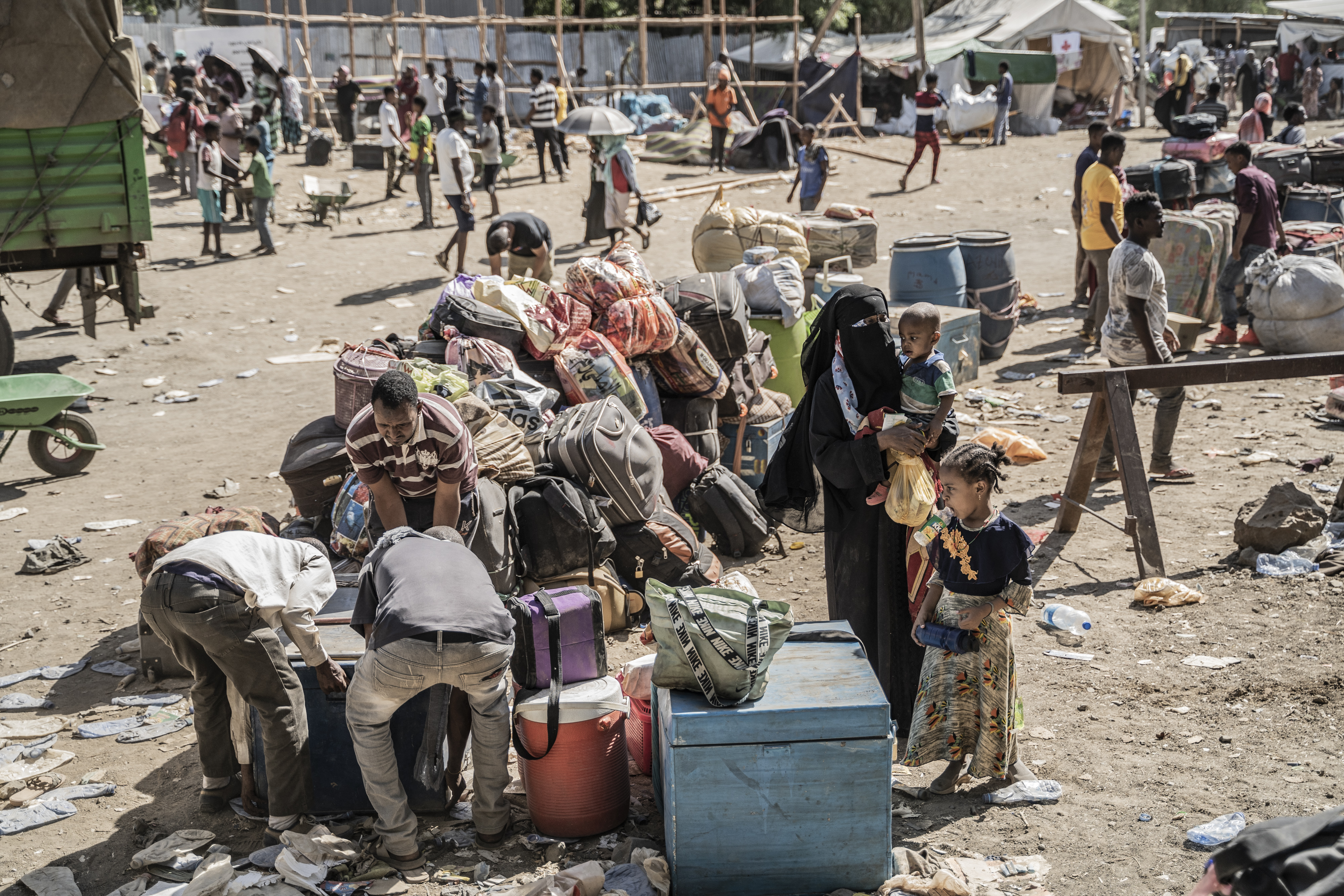 Refugees who crossed from Sudan to Ethiopia put their belongings on the ground for a security check in Metema