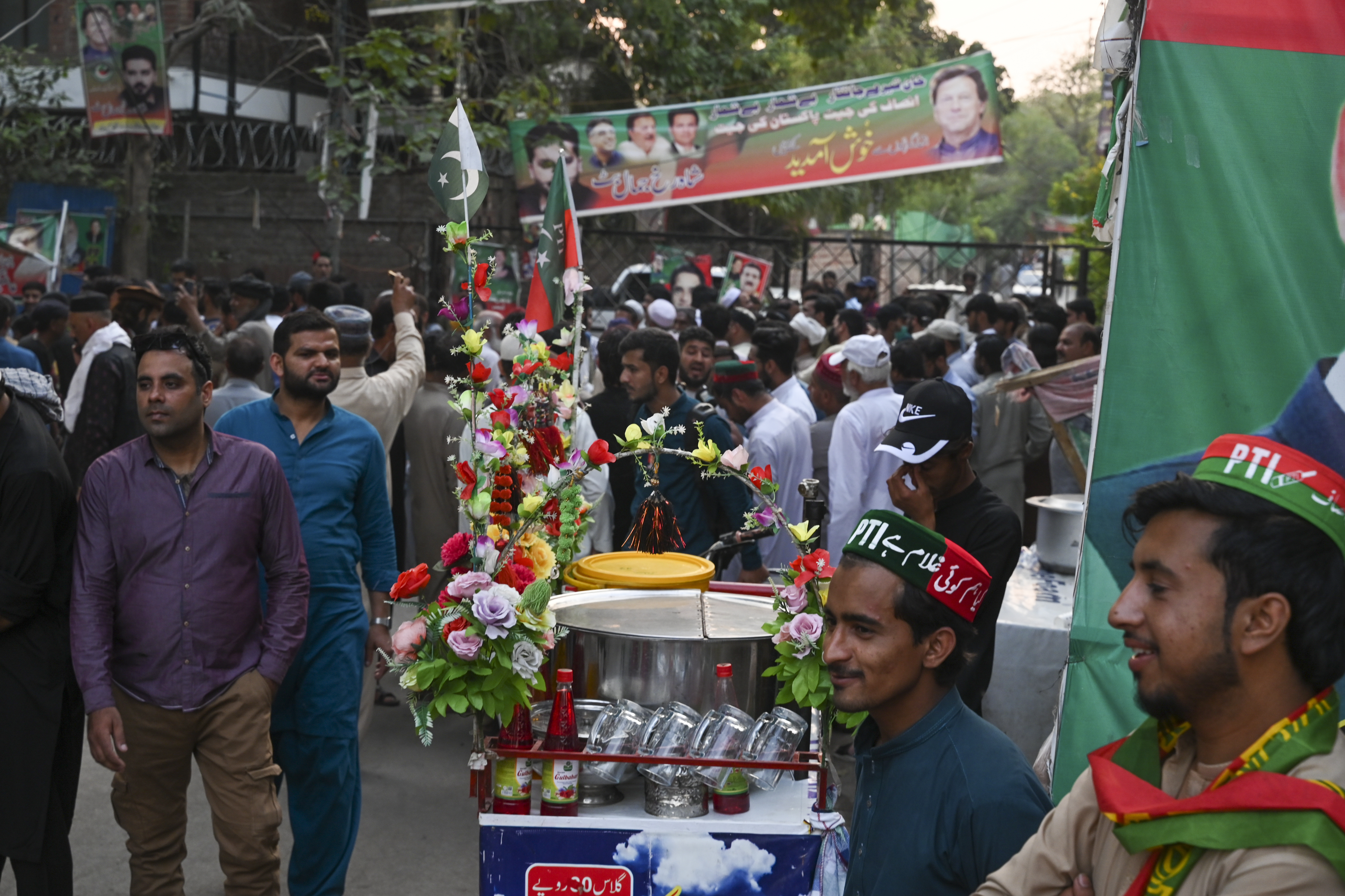 Tehreek-e-Insaf (PTI) party activists and supporters gather outside Pakistan's former Prime Minister Imran Khan's residence to listen his speech, in Zaman Park in Lahore on May 13, 2023