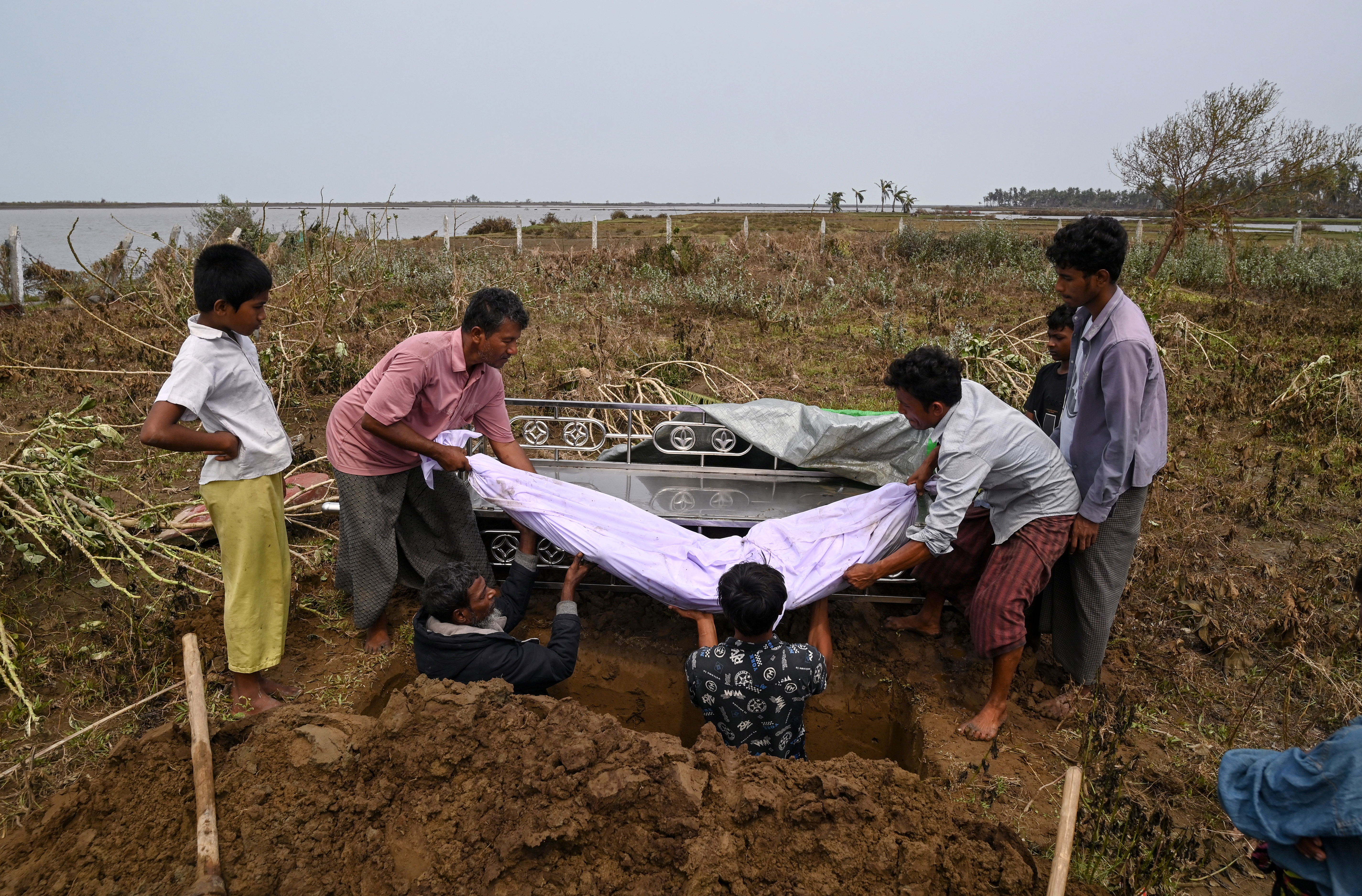 People carry the body of a victim during a funeral near Basara refugee camp in Sittwe
