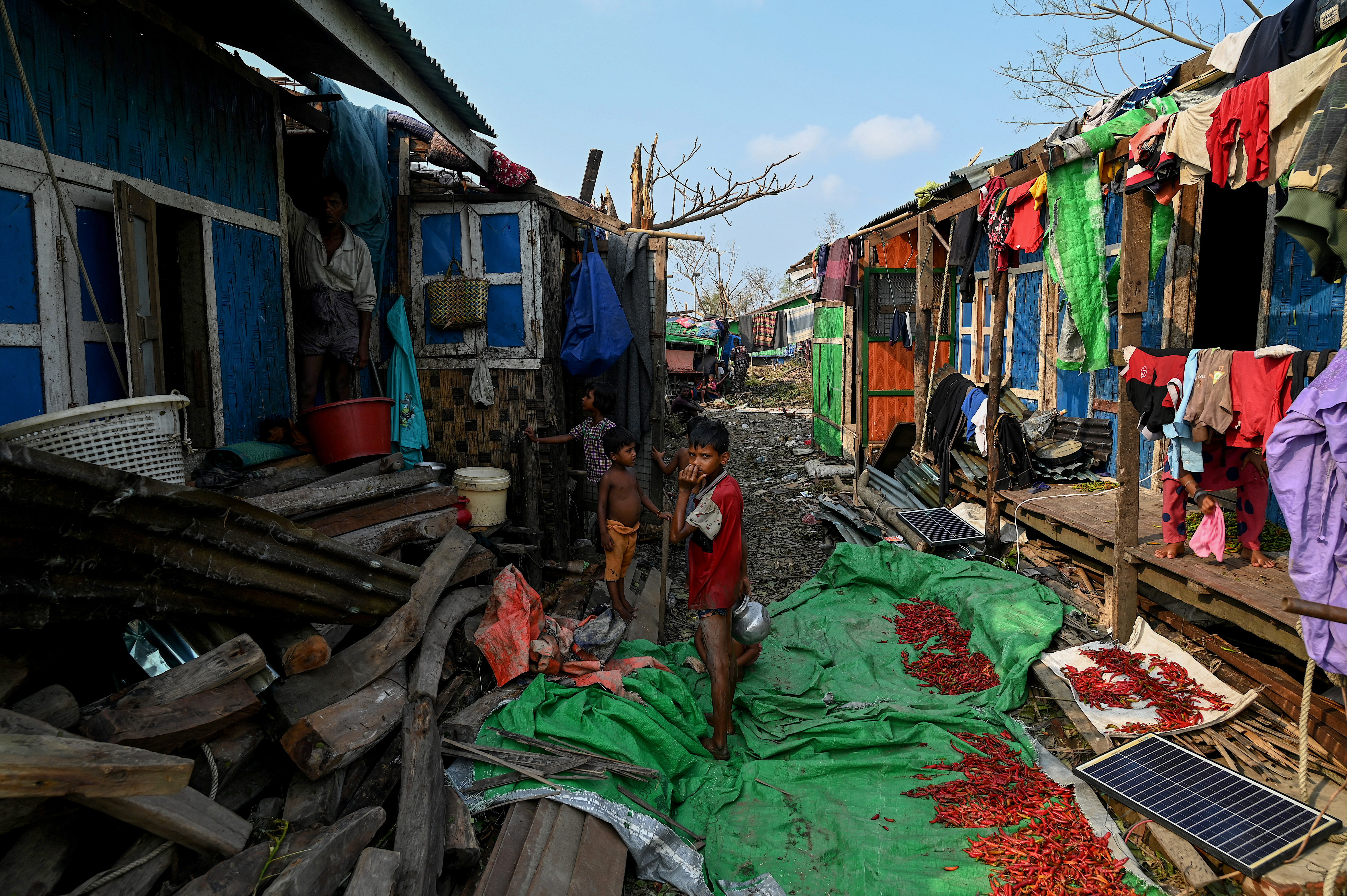 Rohingya children stand by destroyed houses at Ohn Taw Chay refugee camp in Sittwe