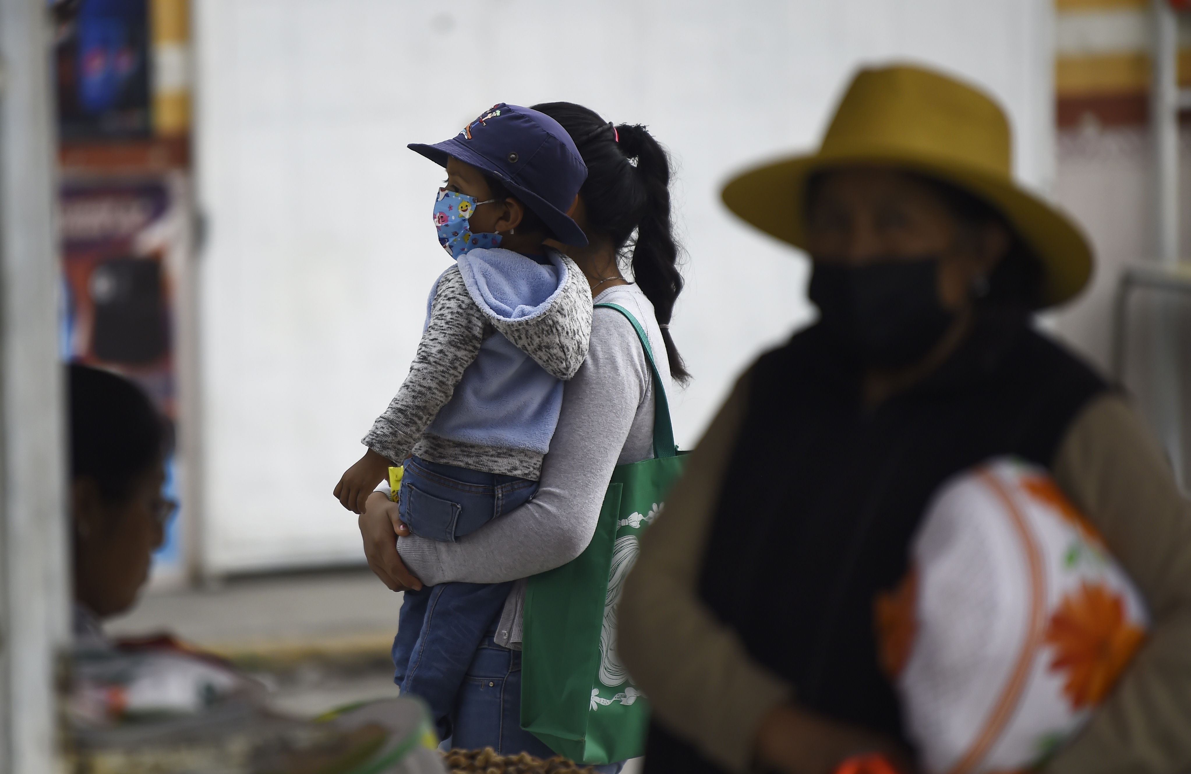 Residents wear protective masks due to the falling ashes from the Popocatepetl volcano, in the village of Santiago Xalitzintla