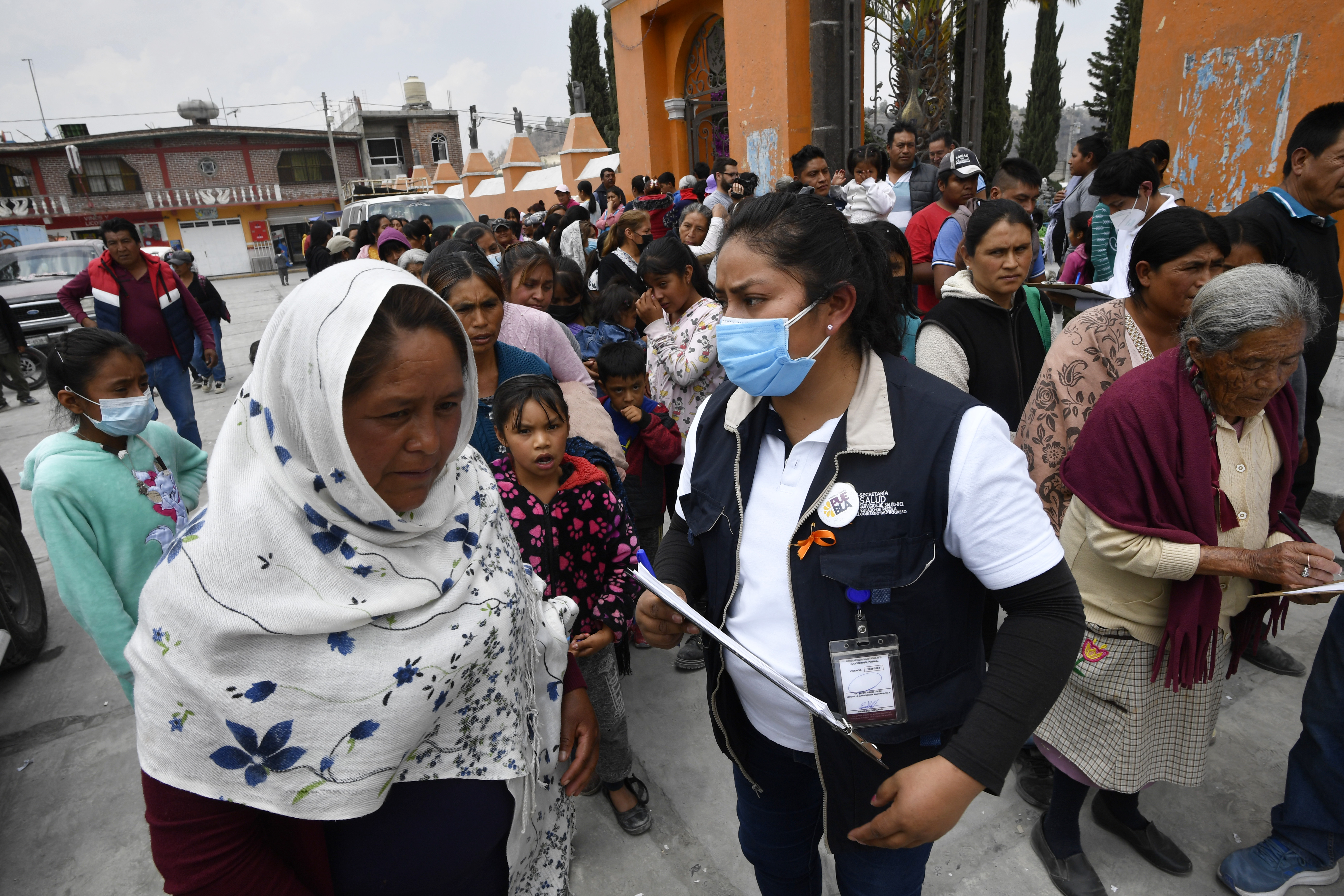 Residents line up to receive a protection kit in case of ash fall in the village of Santiago Xalitzintla