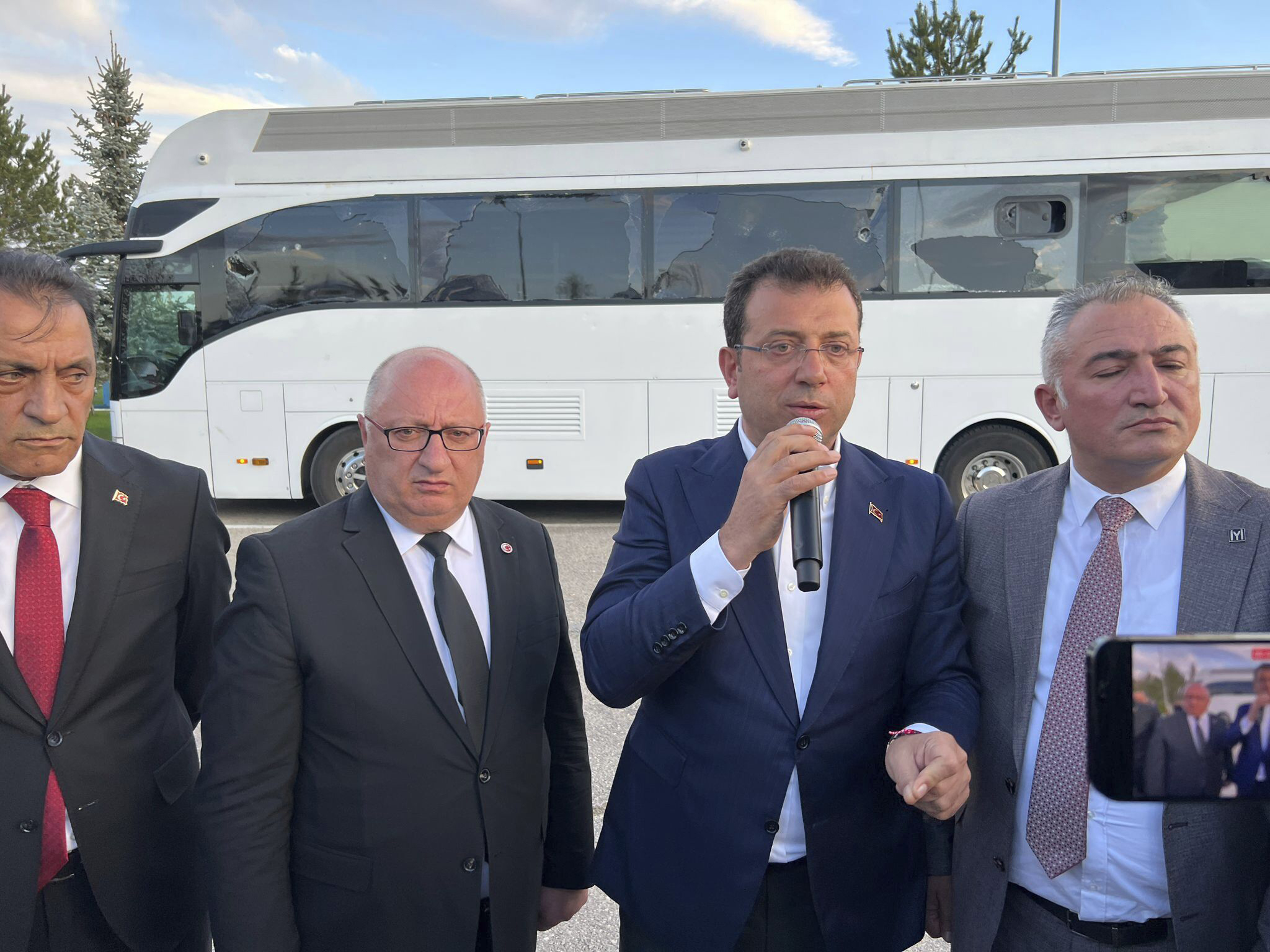 In this handout photo released by Turkish Republican People's Party, CHP, Istanbul Mayor Ekrem Imamoglu, second right, of the main opposition Republican People's Party, CHP, addresses supporters next to his election campaign bus during a rally in Erzurum, Turkey, Sunday, May 7, 2023. More than a dozen people have been detained over violence against an opposition election rally in Turkey's eastern city of Erzurum over the weekend, the country's justice minister said Monday. (CHP via AP)