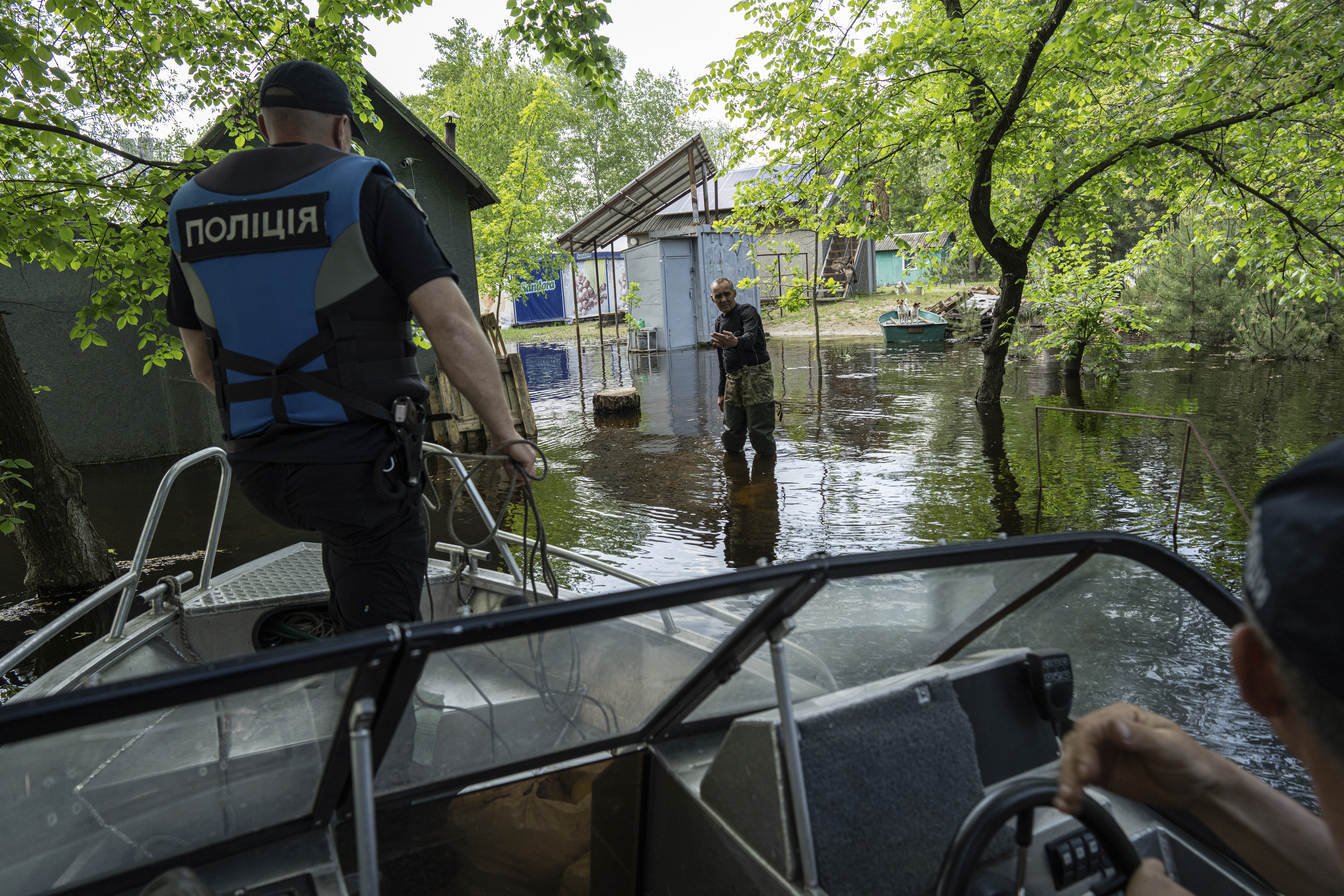 Ihor Medyunov, a local hunter greats police officers at the his flooded courtyard