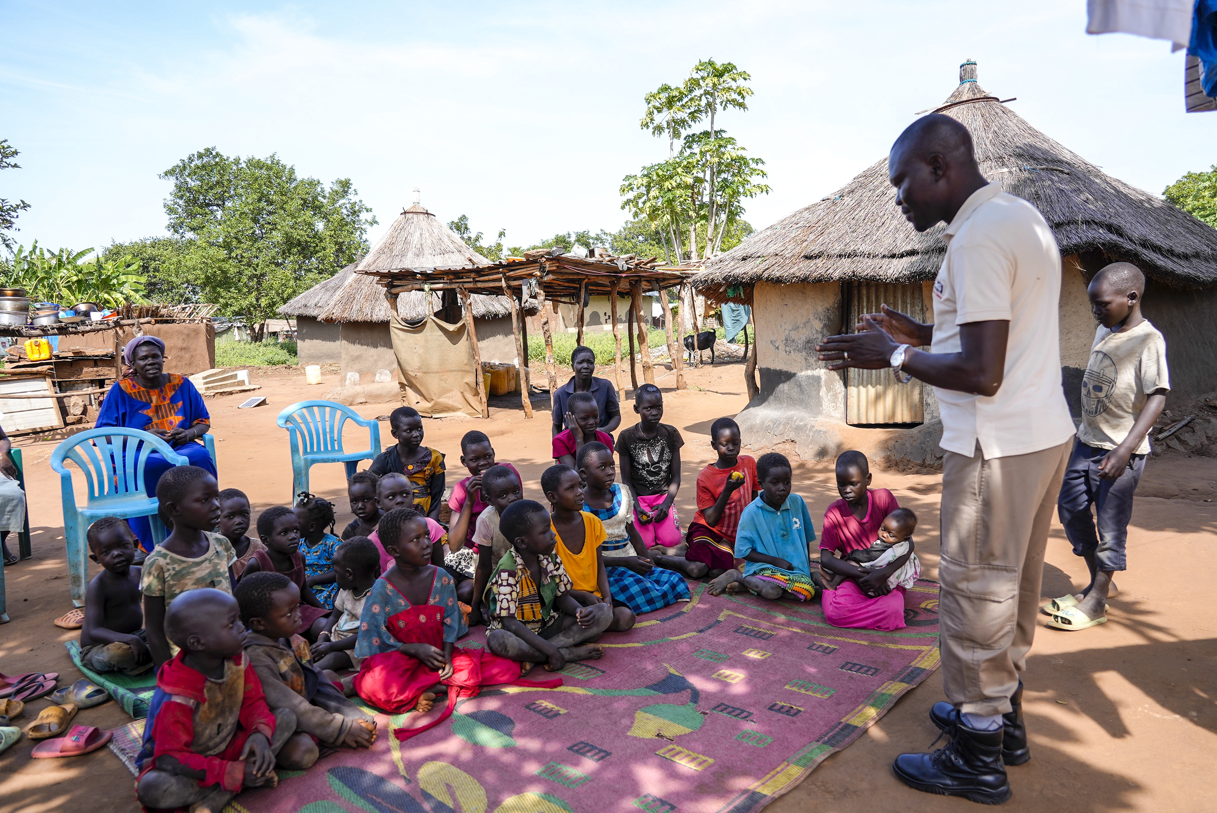 A staff member from the Mines Advisory Group (MAG) teaches children about the risks of unexploded mines