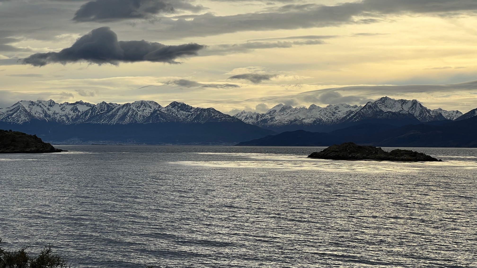 wide view of Navarino Island with snow-capped mountains in background and sea in foreground