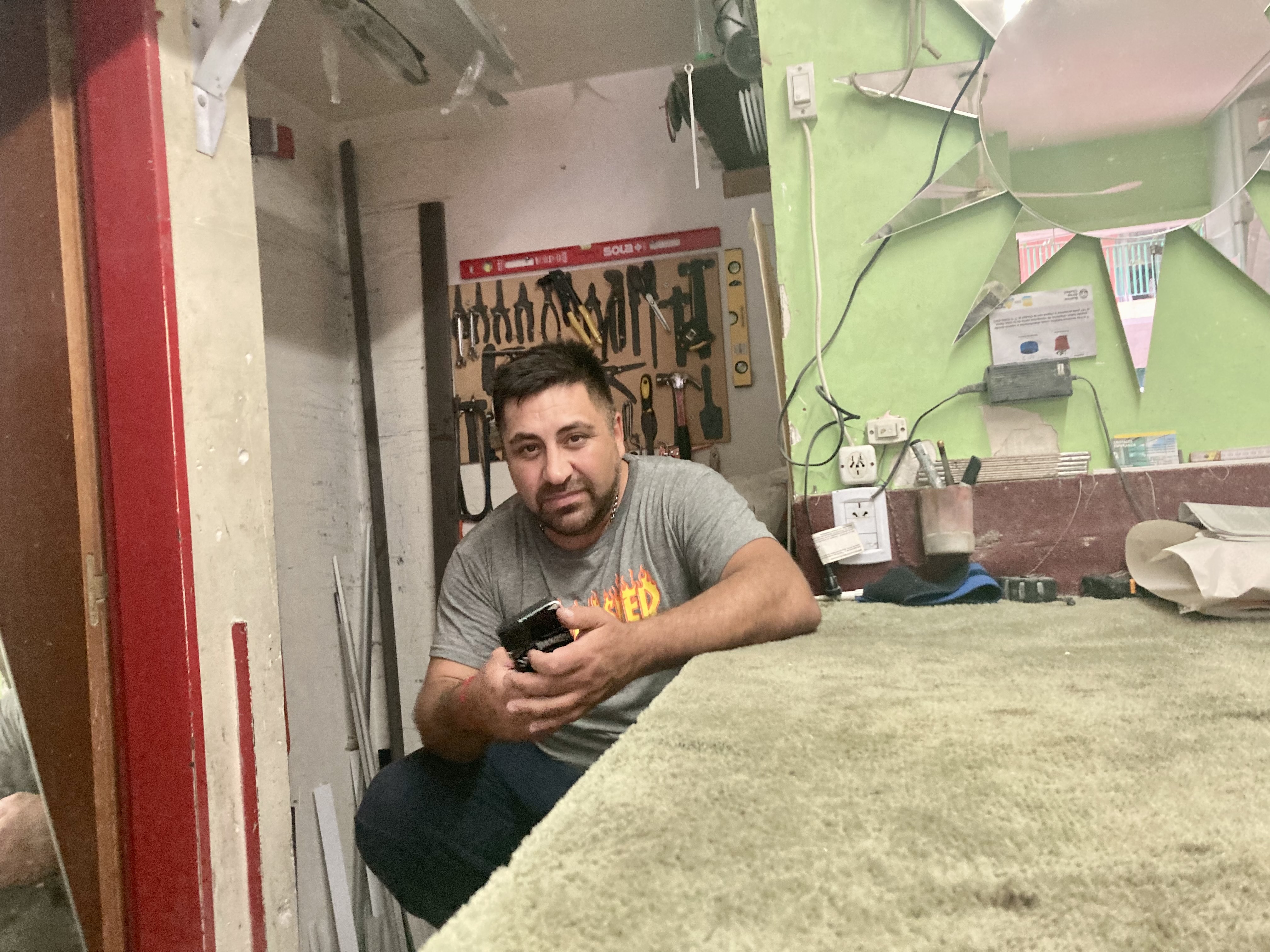Diego Barrera, a glass store owner, sits in his store in Buenos Aires, Argentina.