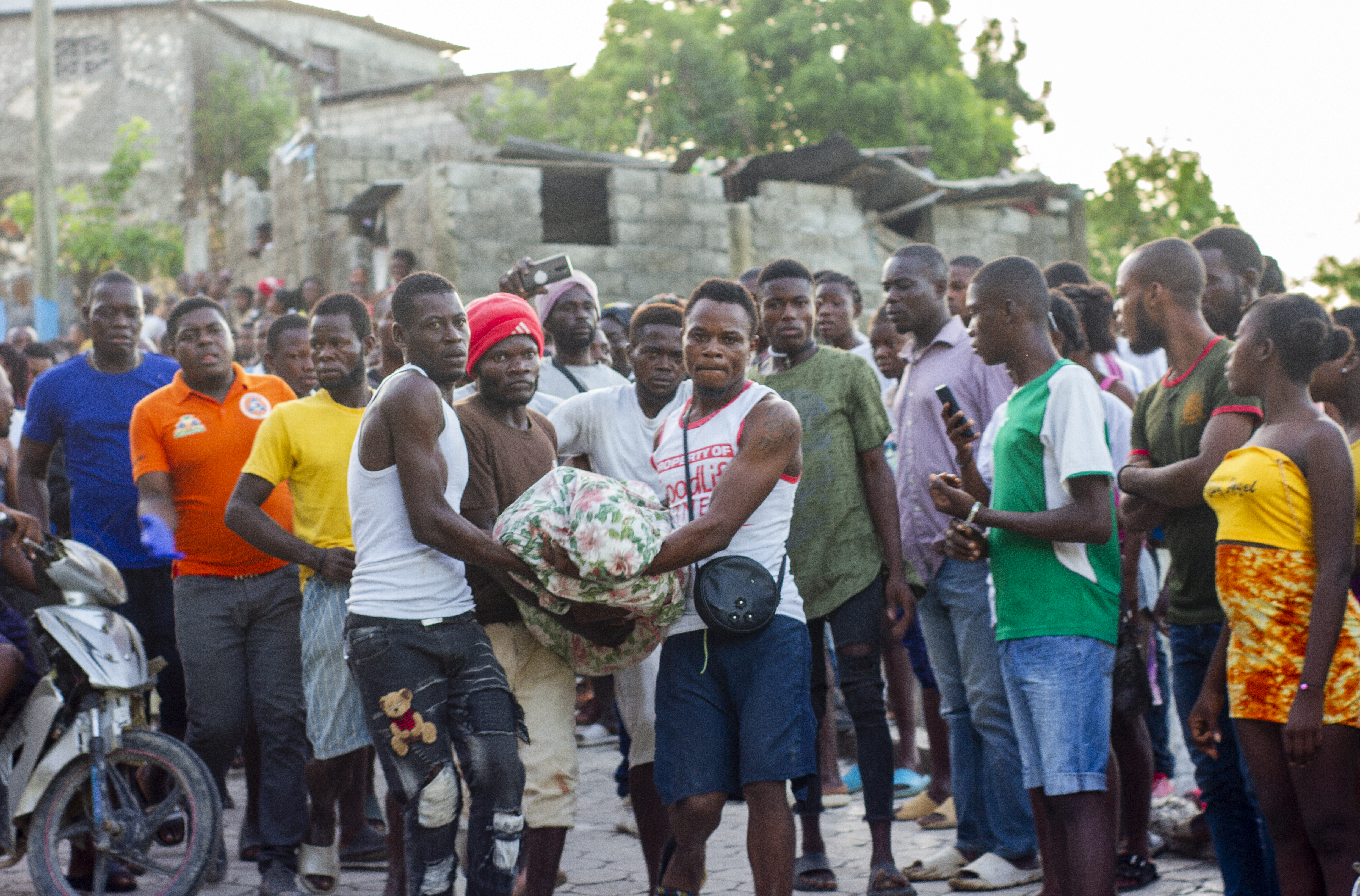 A group of men carry the body of a deceased person