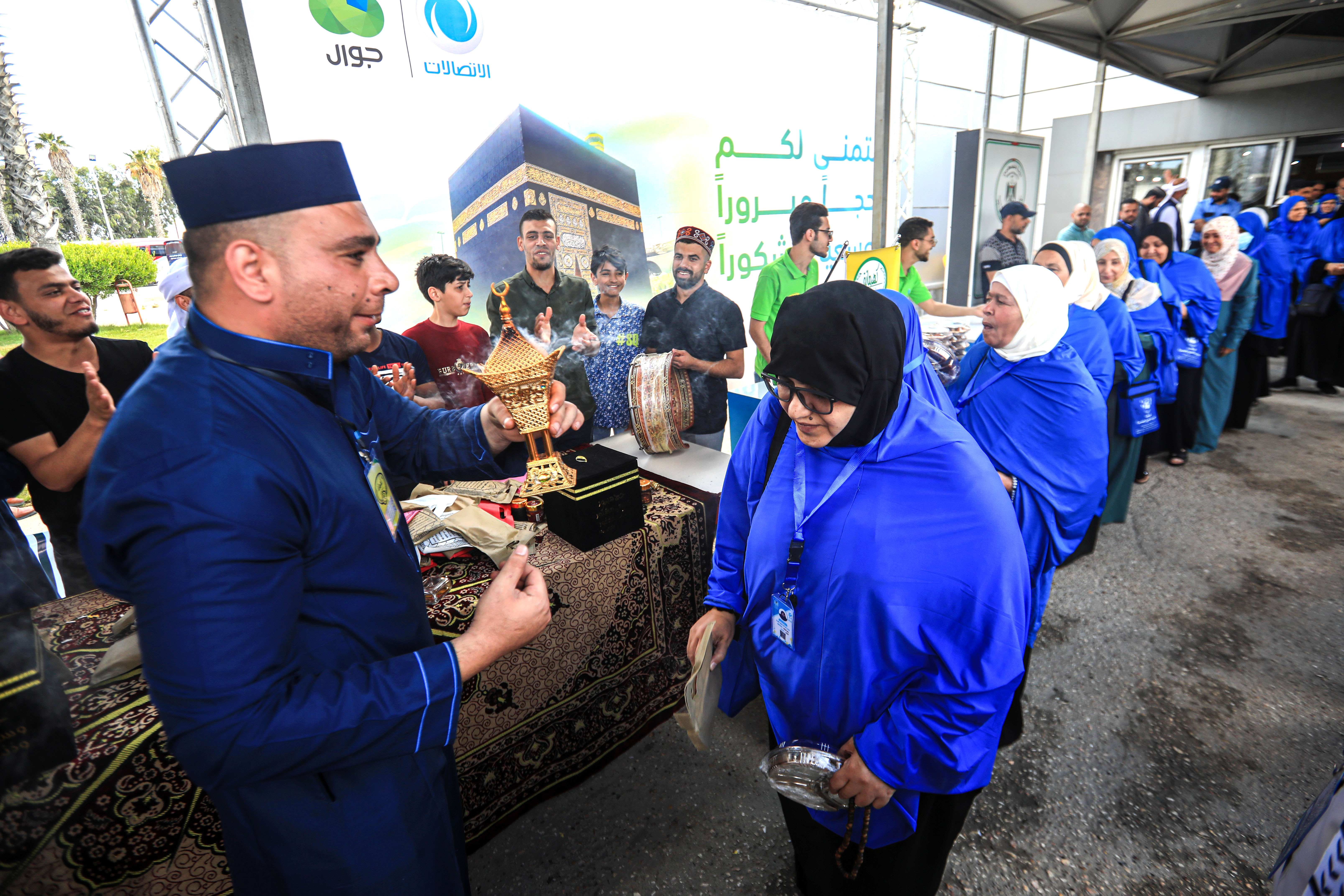 A man welcome a queue of pilgrims