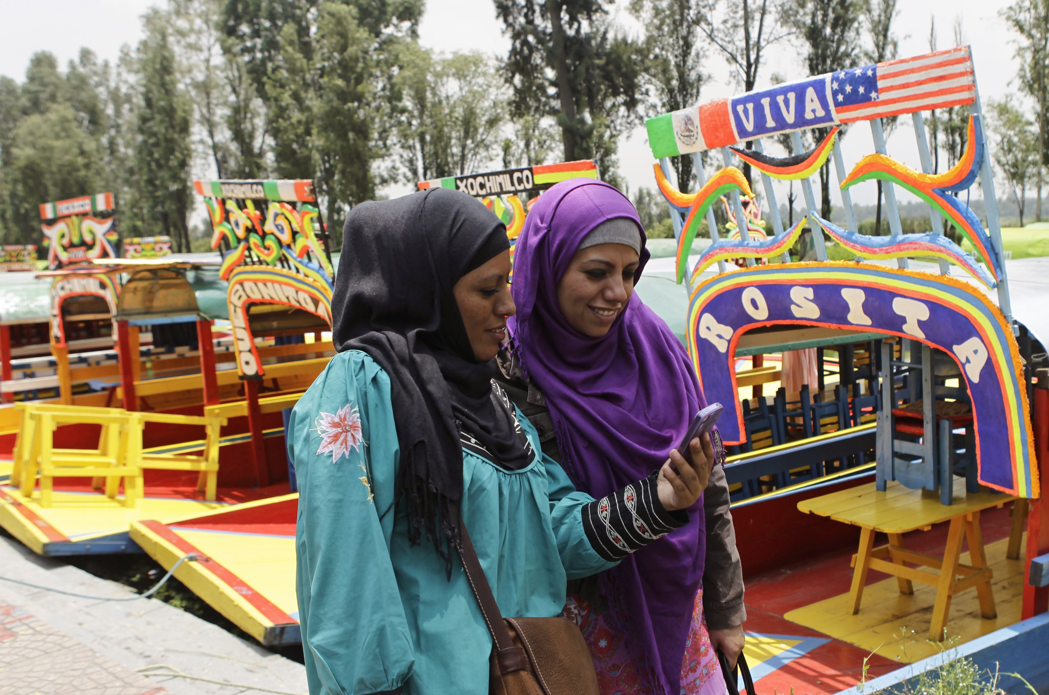 Muslim women walk past trajineras (boats) at the canals of Xochimilco as they celebrate Eid in Mexico City 