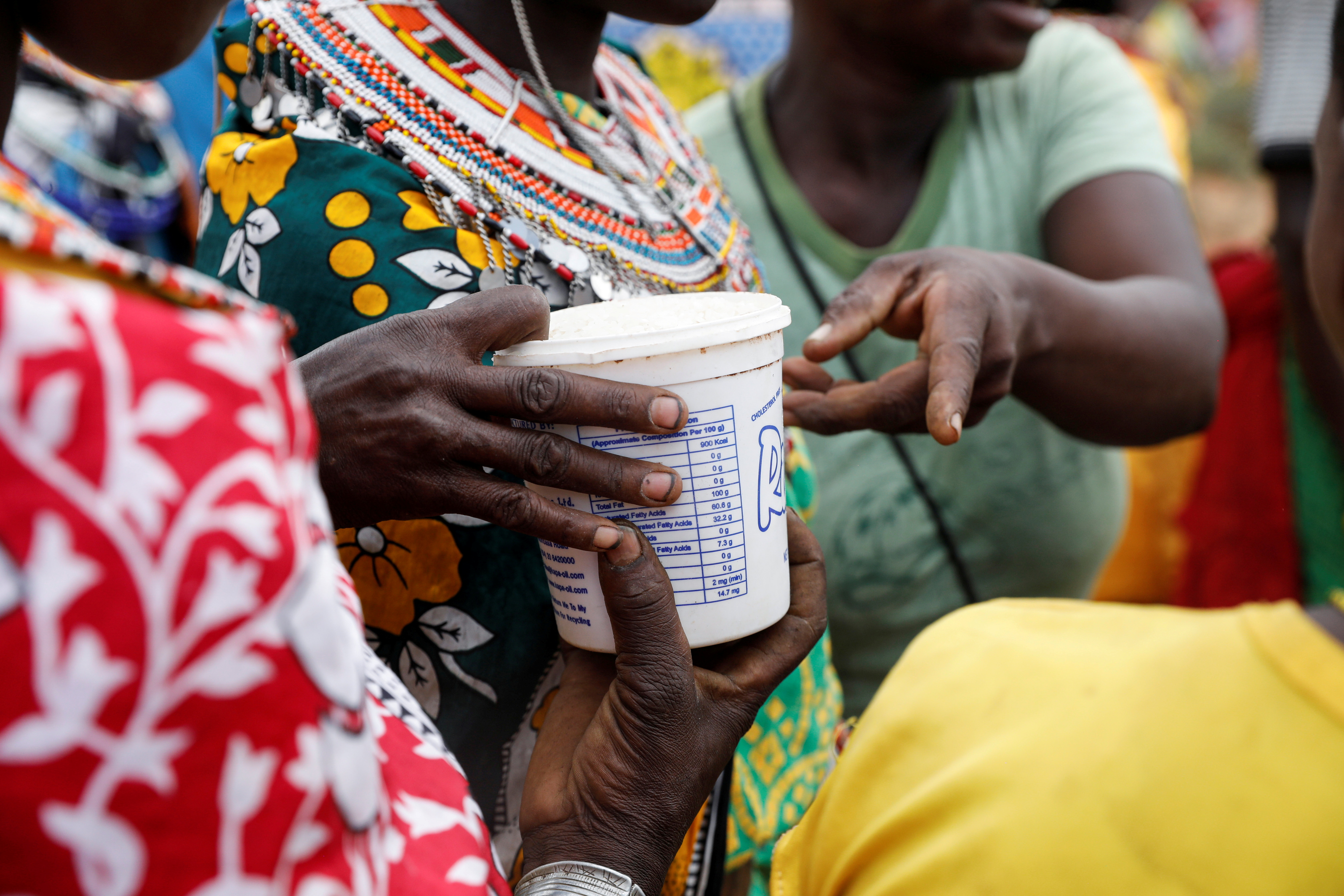 Women from the Samburu tribe receive a food donation given due to an ongoing drought, in the town of Oldonyiro, Isiolo county, Kenya, October 8, 2021. Picture taken October 8, 2021. REUTERS/Baz Ratner REFILE - CORRECTING INFORMATION