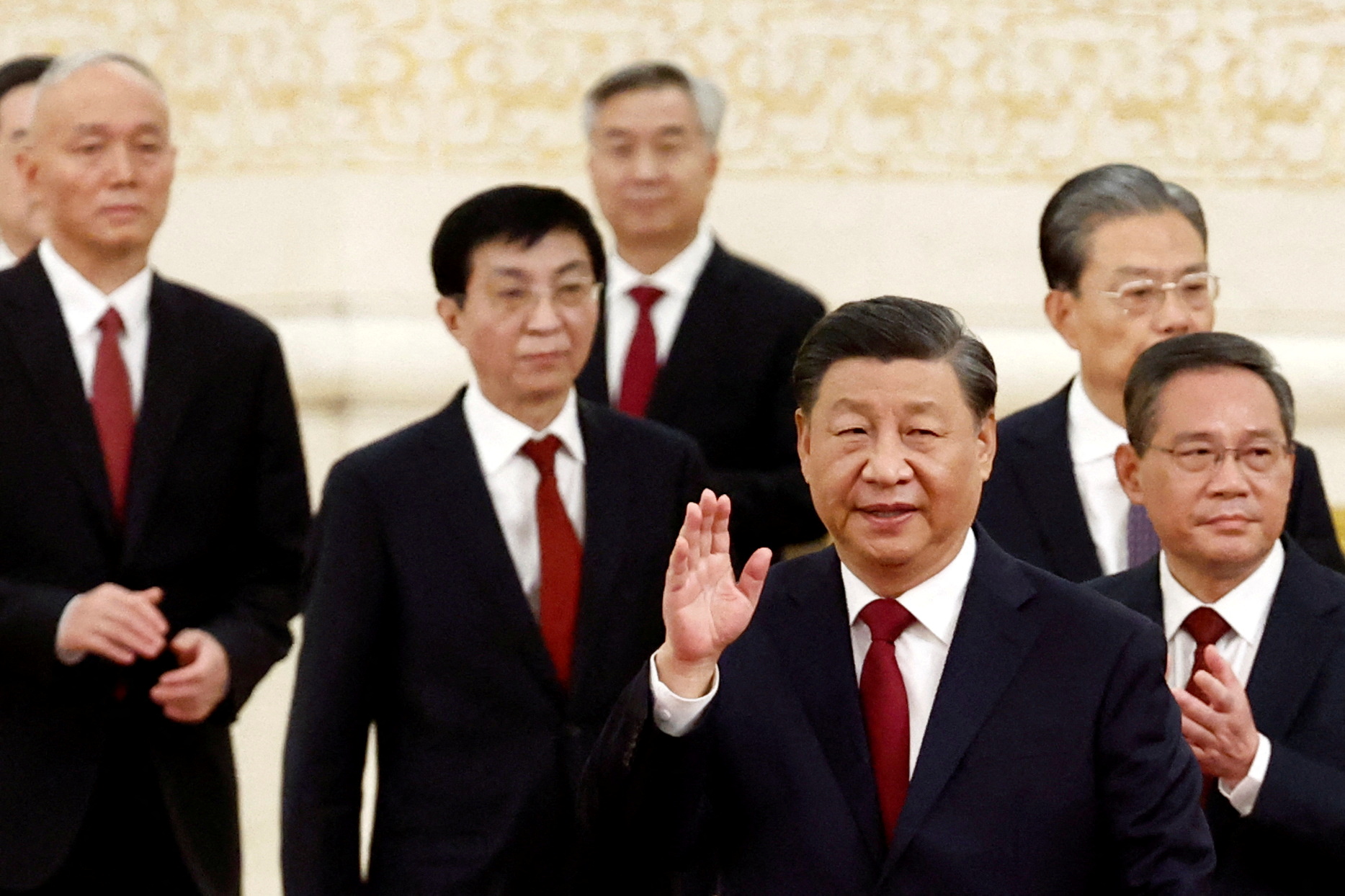 Xi Jinping smiles and waves as he leads his new politburo members to meet the media. Wang Huning is behind him. He is not smiling.