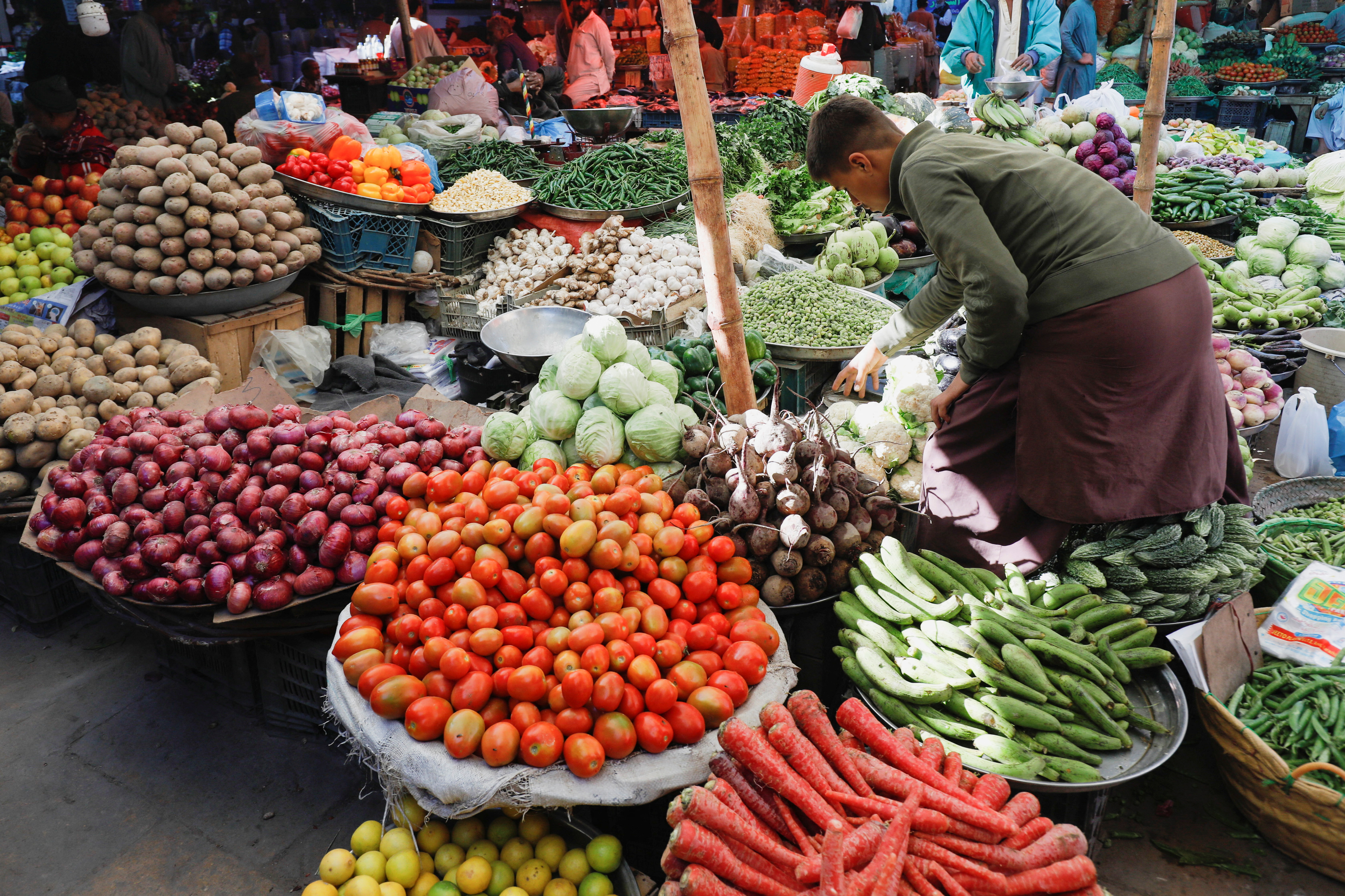 A boy buys vegetables from a makeshift stall at a market in Karachi, Pakistan February 1, 2023.