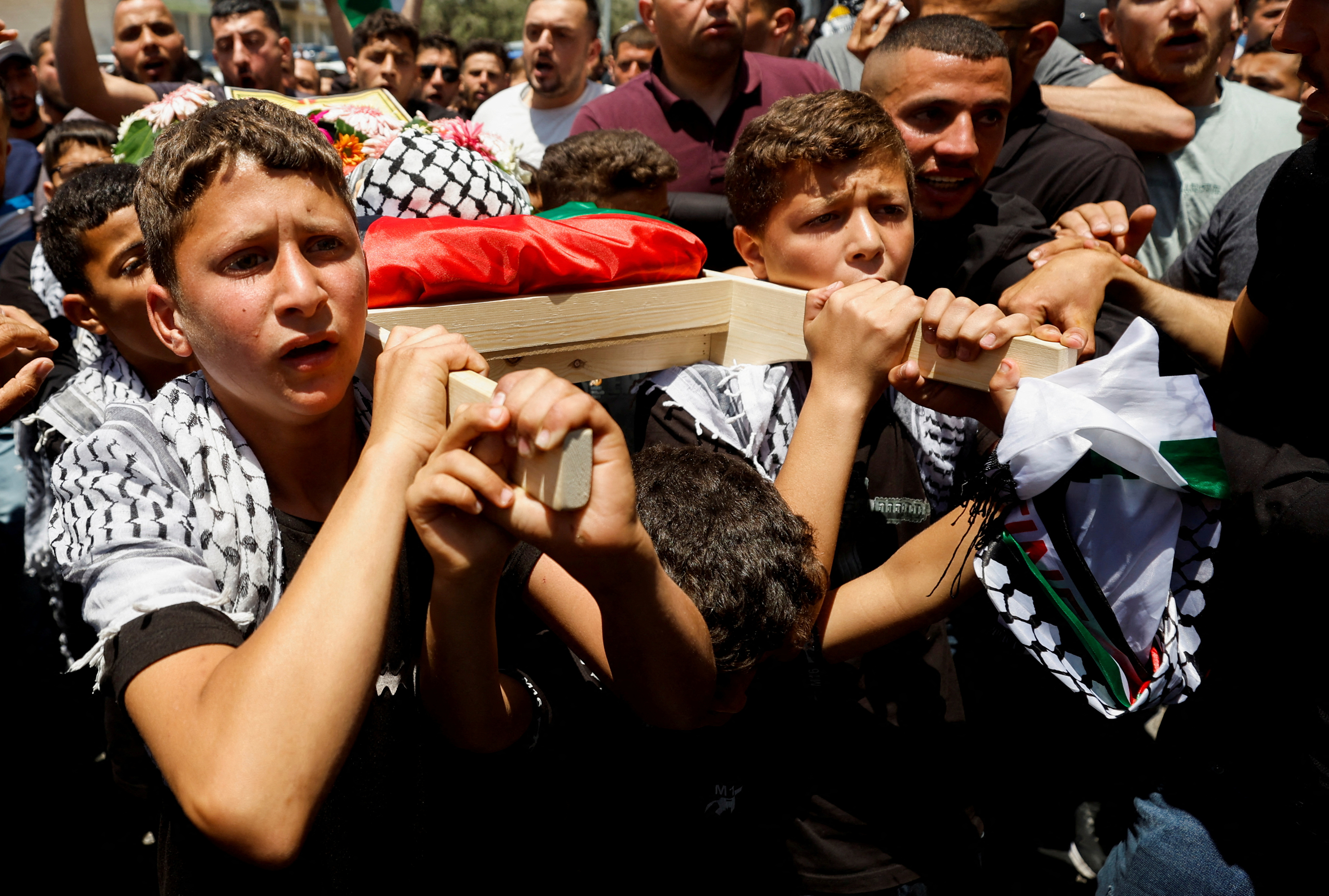 Mourners carry the body of three-year-old Palestinian boy Mohammad al-Tamimi who died of his wounds after being shot by Israeli forces