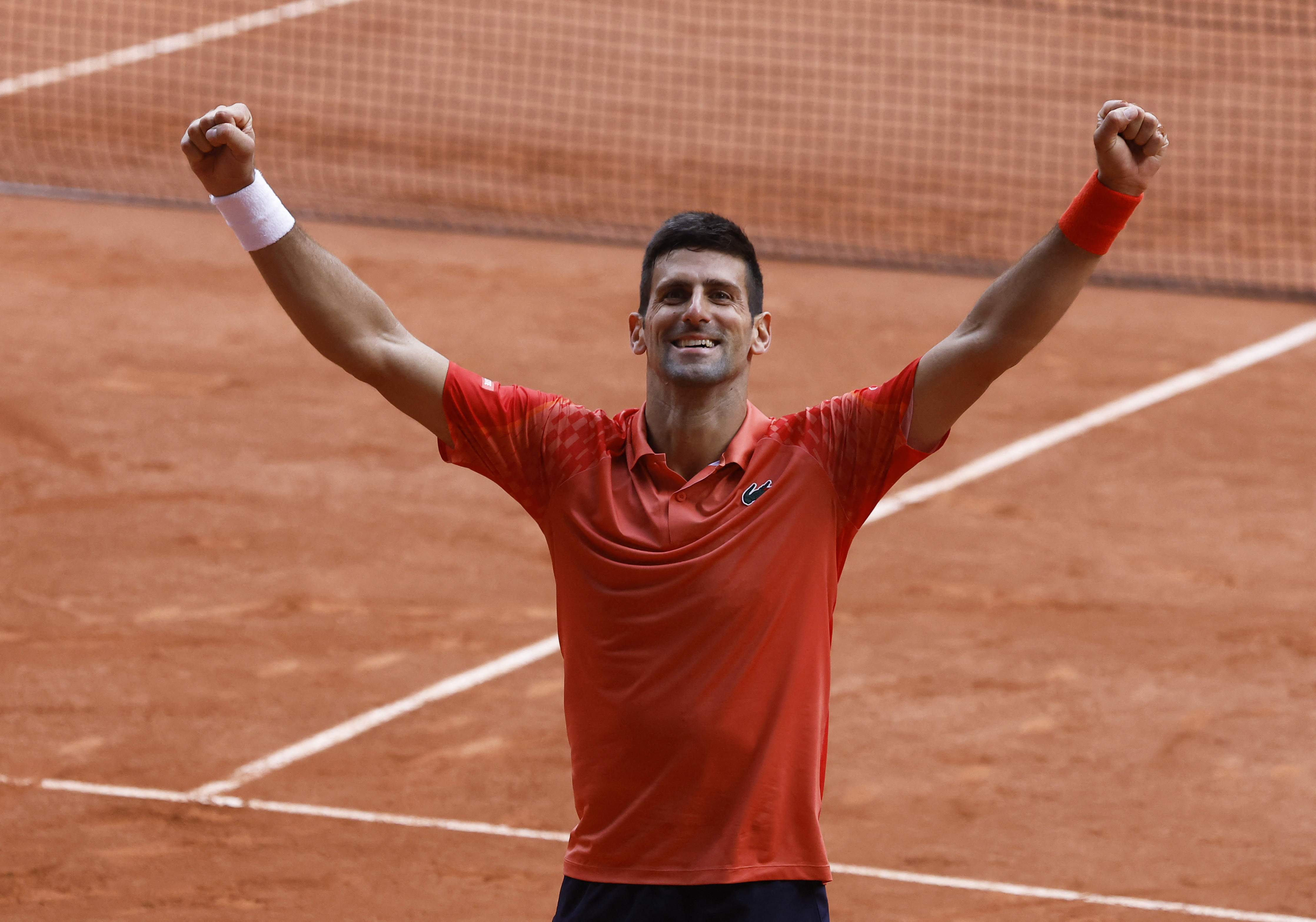 Djokovic holds his arms aloft in celebration